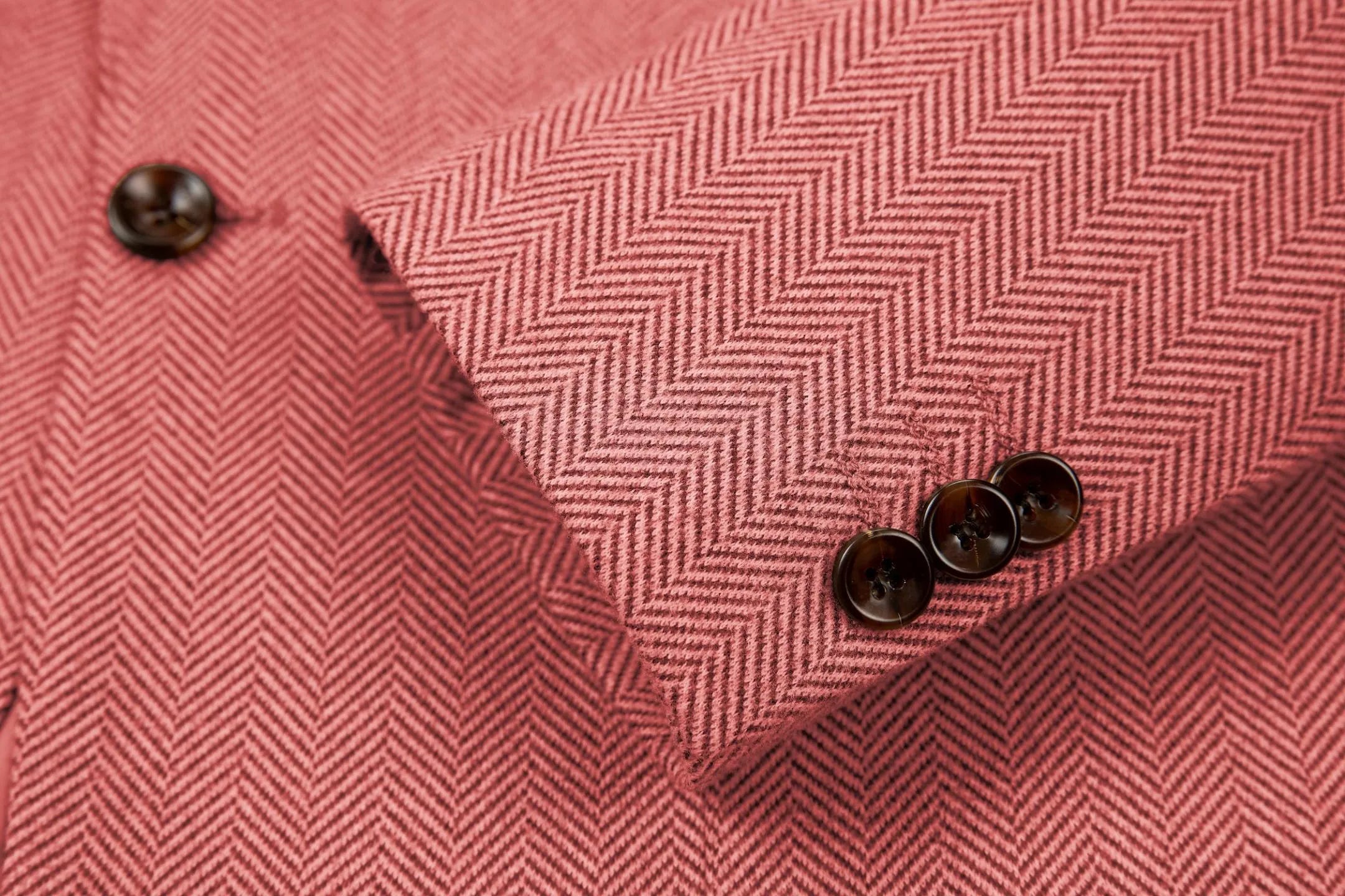Detailed shot of men's red herringbone business suit sleeve – showcasing fine tailoring and classic 2-piece style