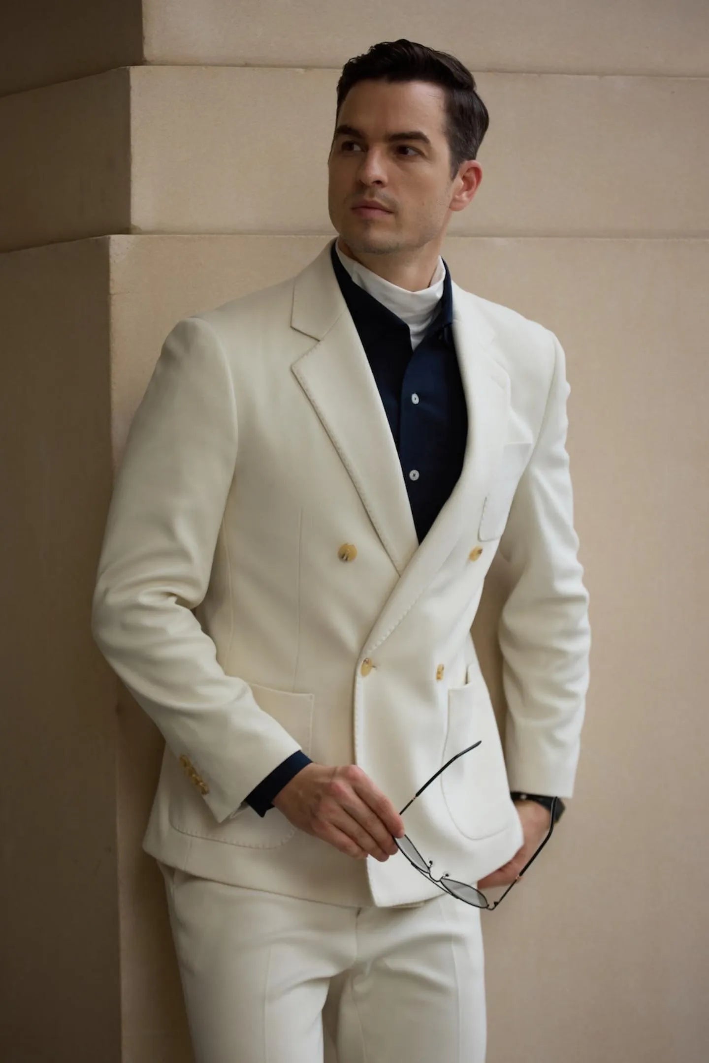 Close up of white herringbone tweed double breasted men's blazer with peak lapel and gold buttons