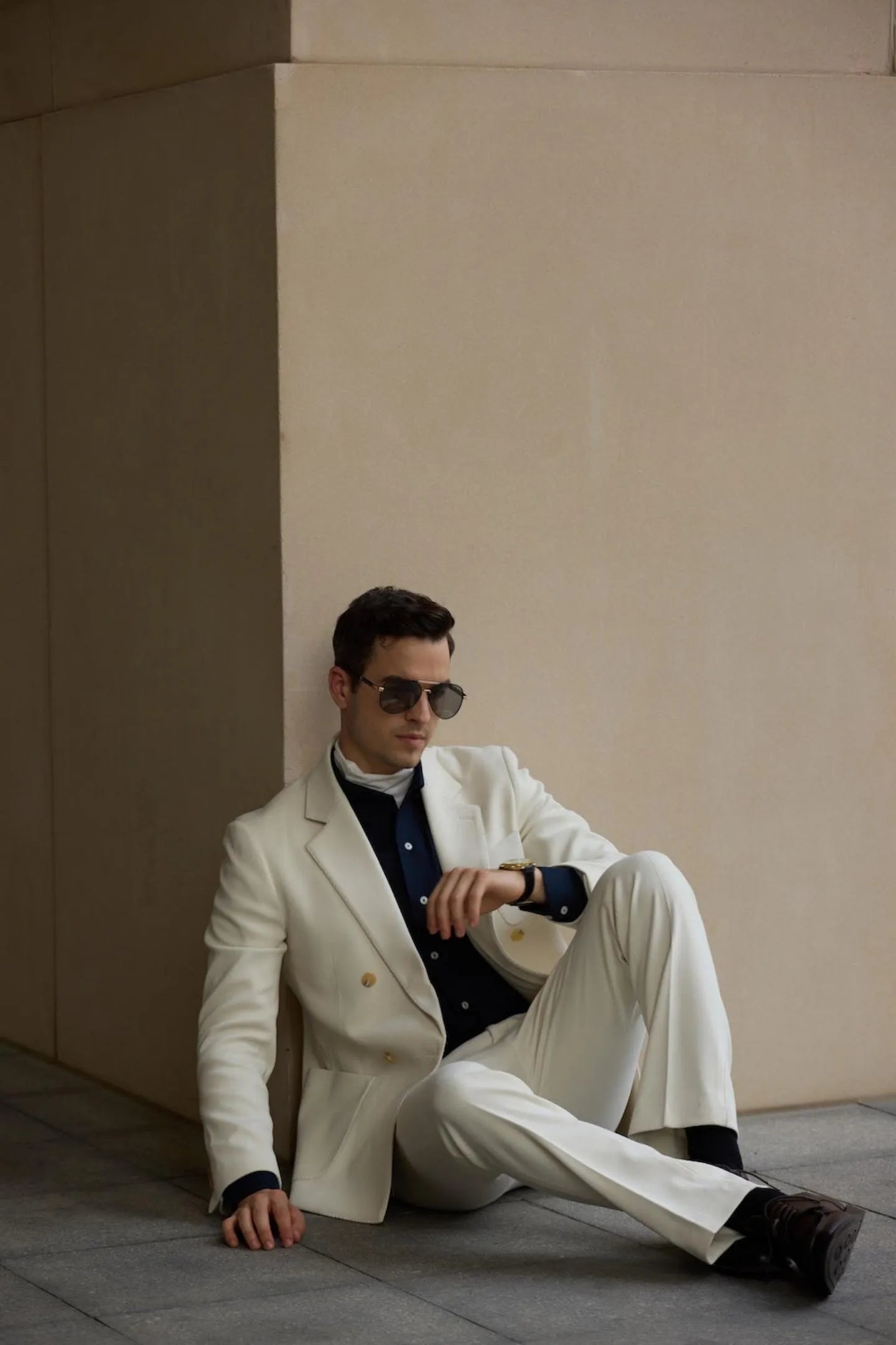 White herringbone tweed men's wedding suit styled with dark shirt, double breasted blazer and tailored pants