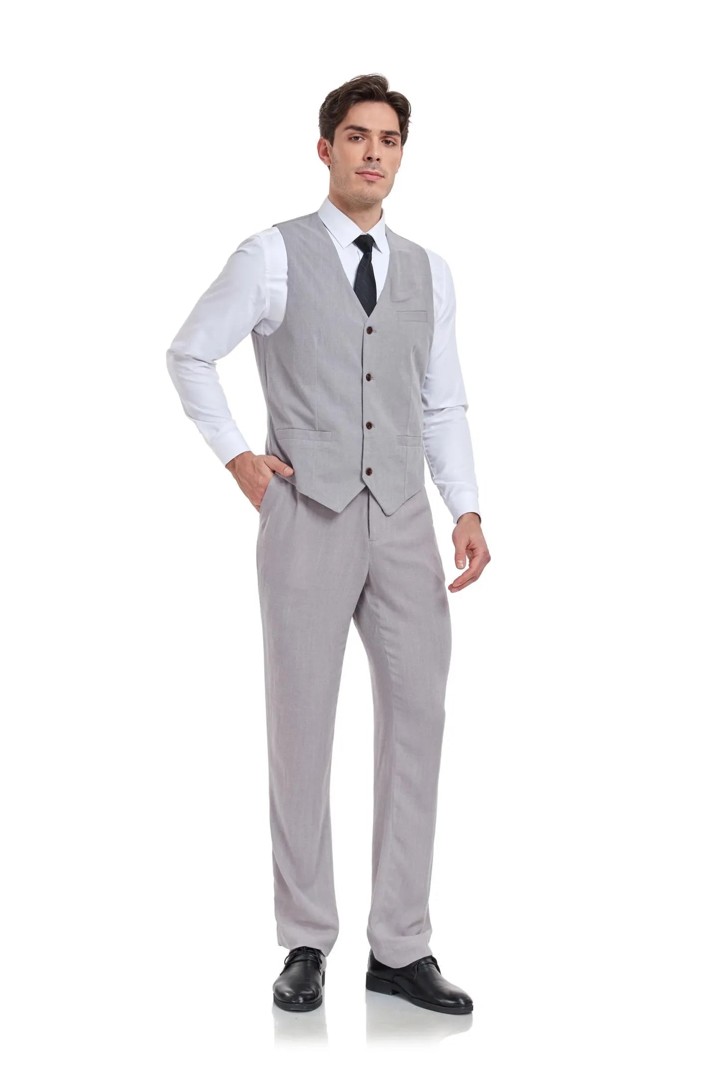 Man in grey linen 2 piece slim fit vest and pants set with white shirt and tie, standing in a casual business style pose.