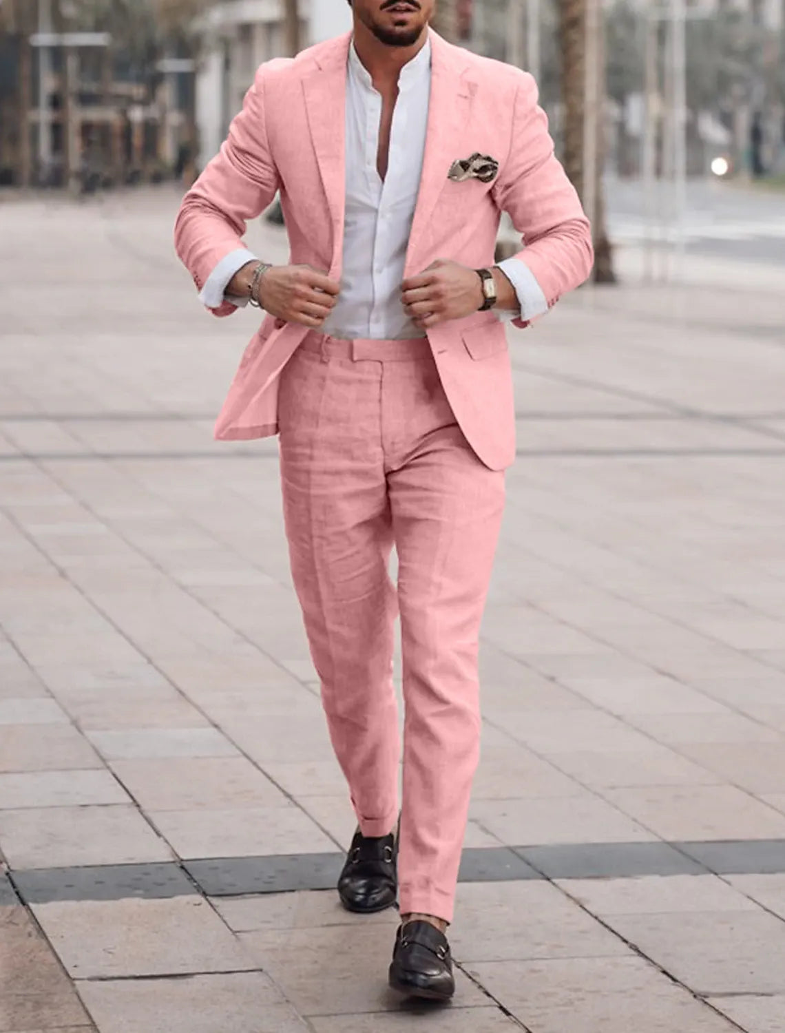 Model wearing soft pink suit jacket and trousers in bright outdoor scene