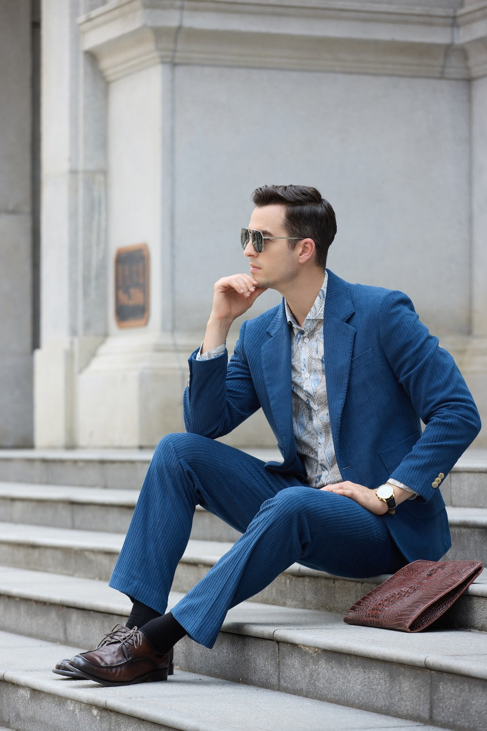 Seated side profile in royal blue corduroy prom suit – casual pose with slim fit trousers