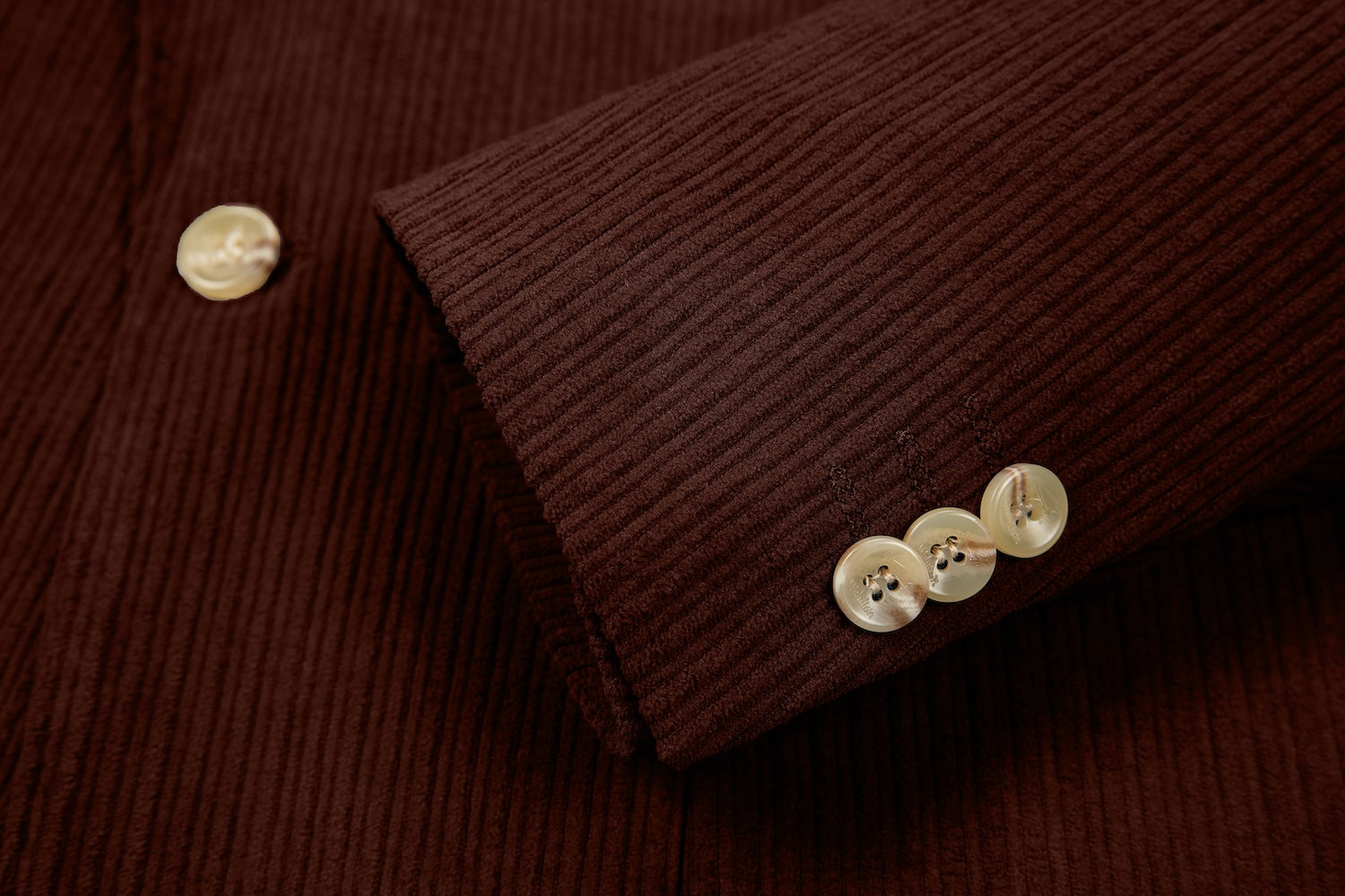 Detail of blazer sleeve in wine red corduroy – buttoned cuff with ridged finish