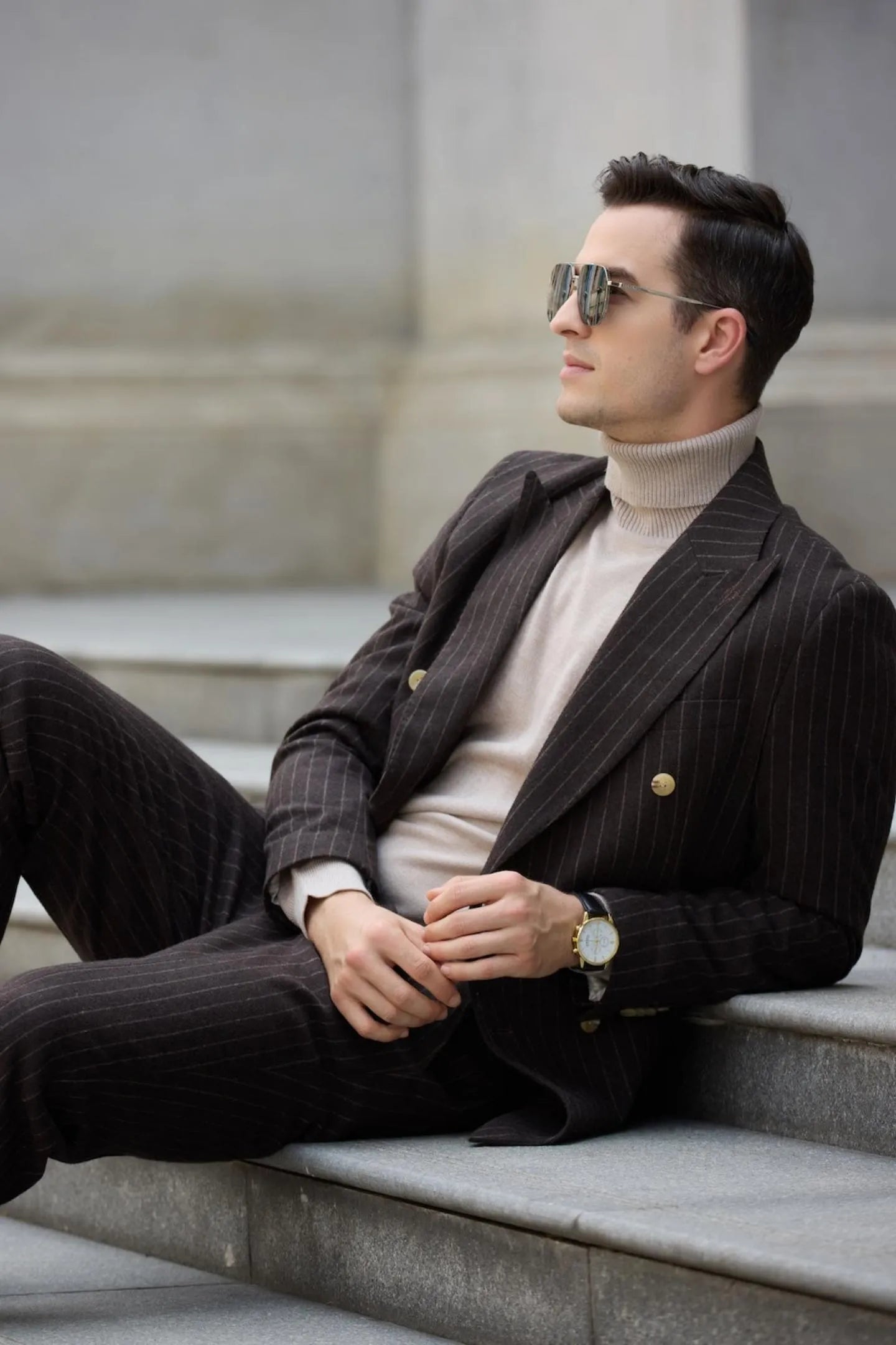 Men's coffee herringbone chalk stripe double-breasted suit – model adjusting cuff and displaying confident posture with a stylish business look.
