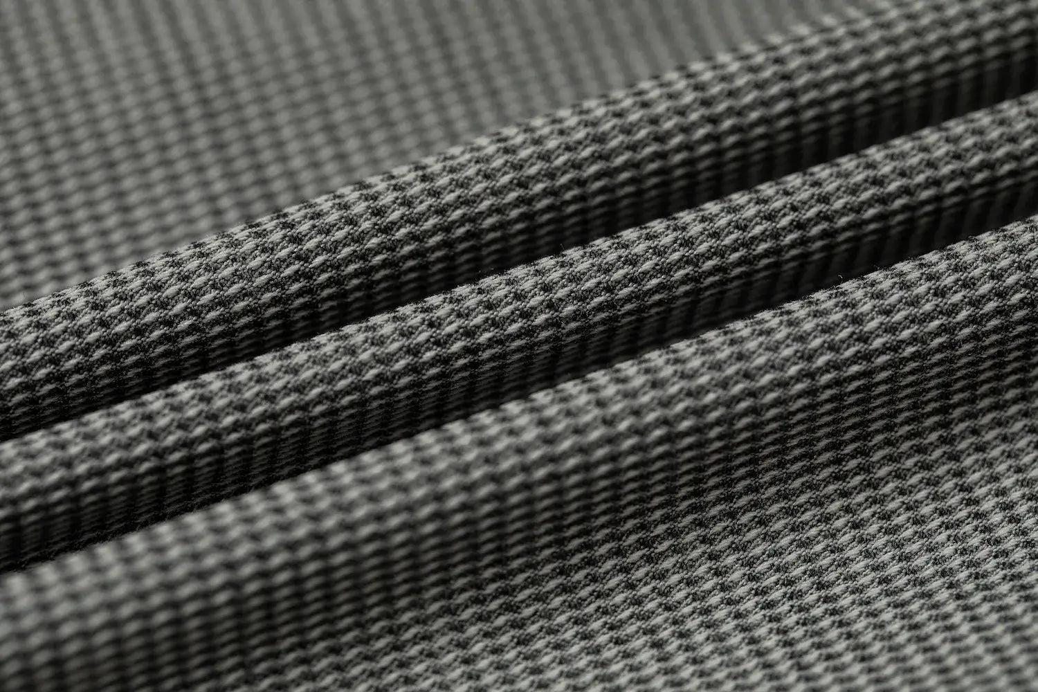 Fabric texture close-up of slim fit men's plaid blazer in subtle grey check pattern