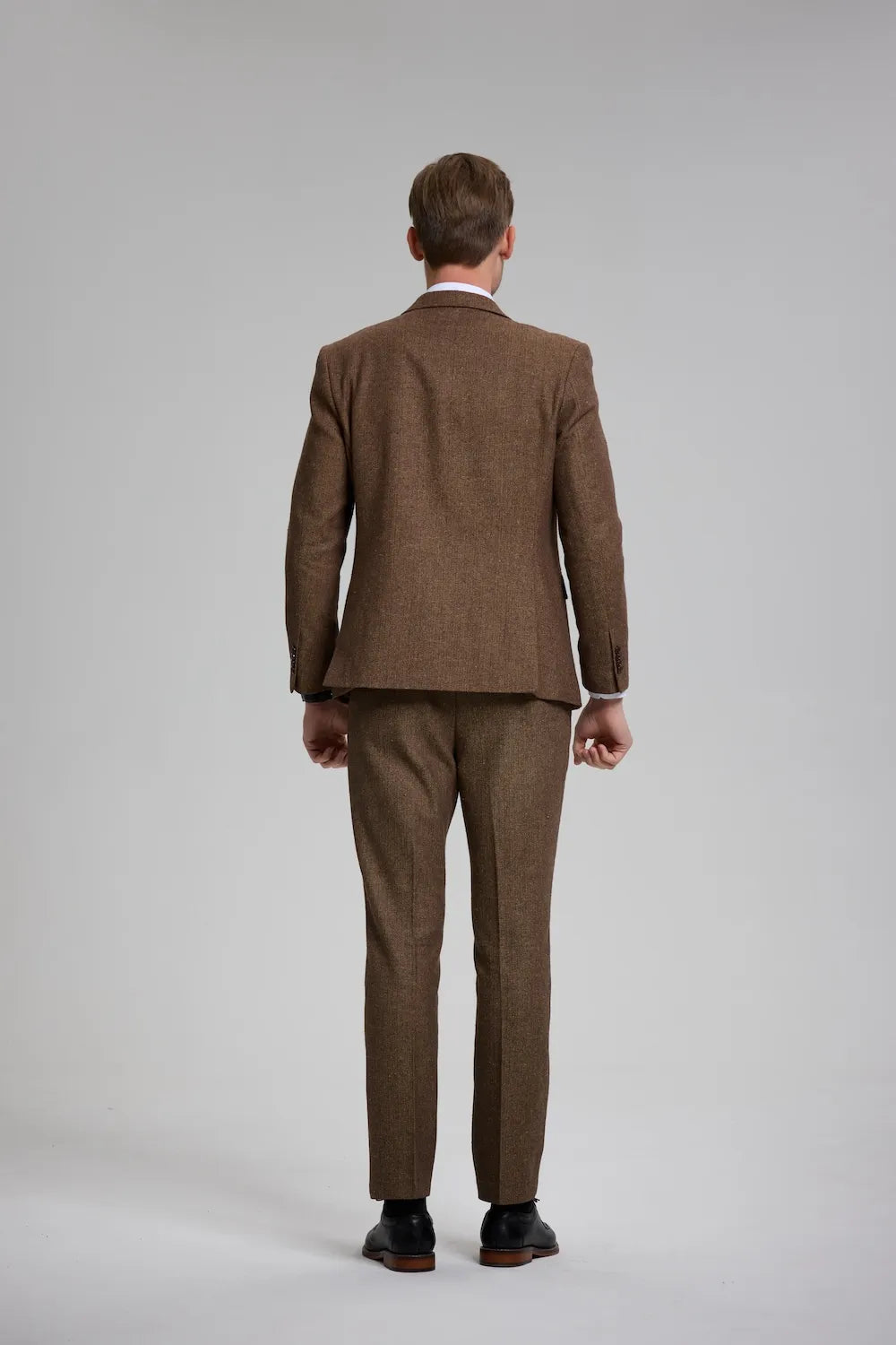 Back view of a brown Versatile Herringbone 3-Piece Suit, highlighting the clean lines and sophisticated fit.