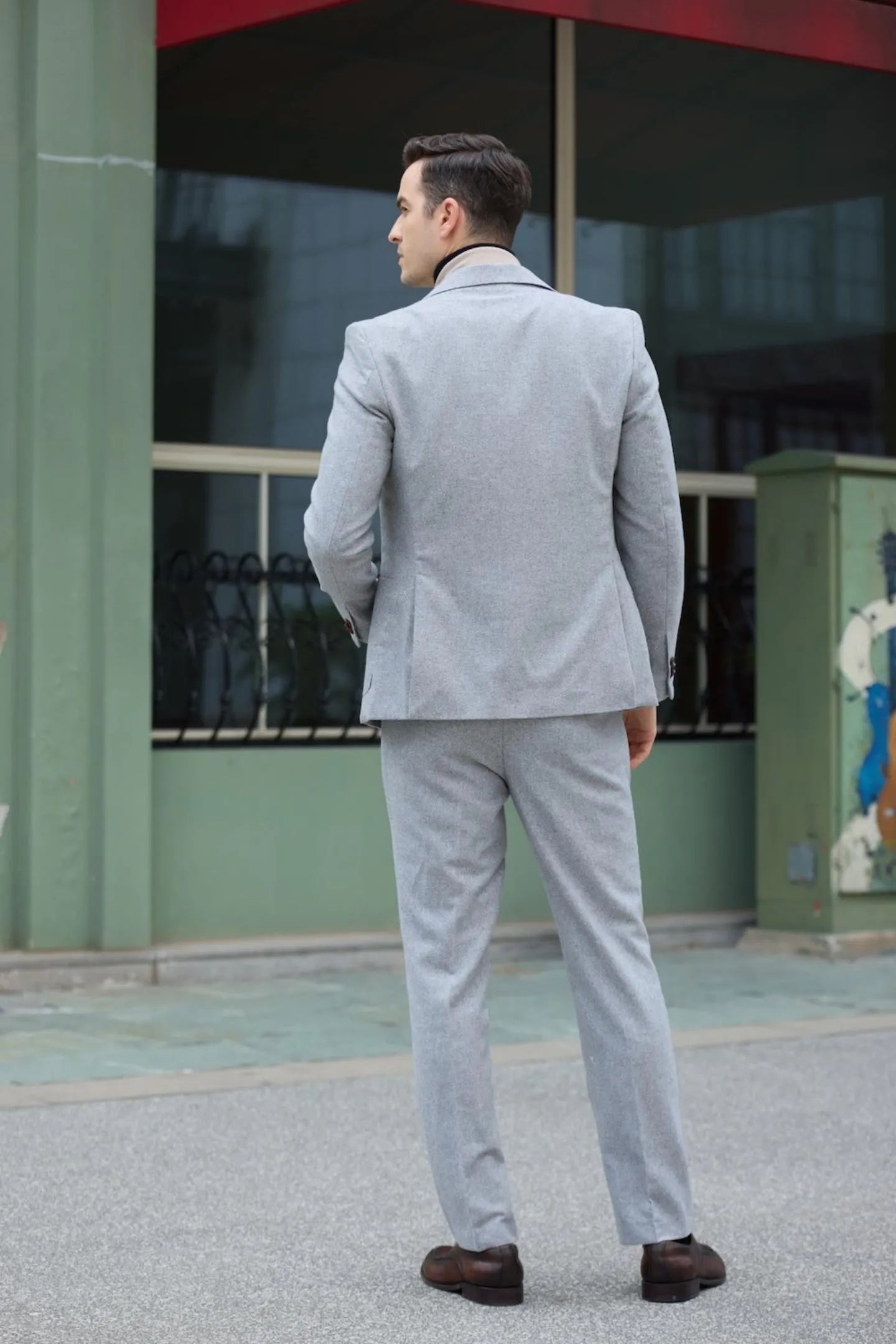 back view of men's gray herringbone two-button suit, showcasing a tailored business style.