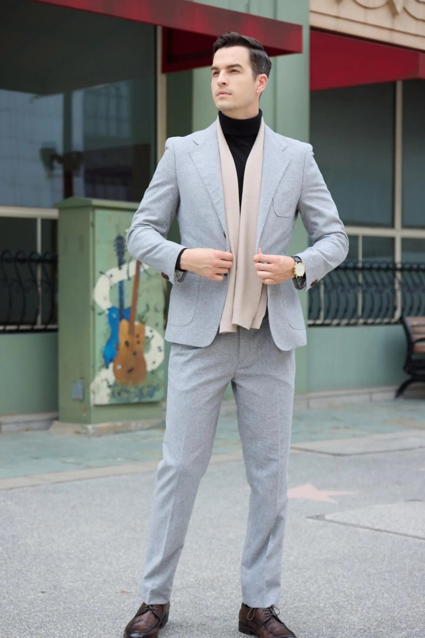 full body view of men's gray herringbone 2 piece suit with two buttons, styled for casual business events.