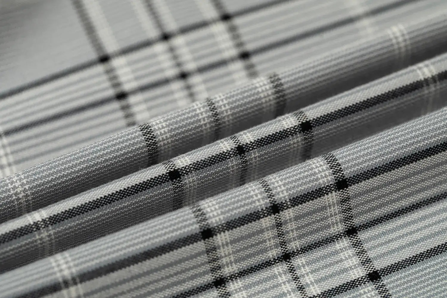 High-resolution close-up of grey plaid fabric showcasing fine weave and pattern.