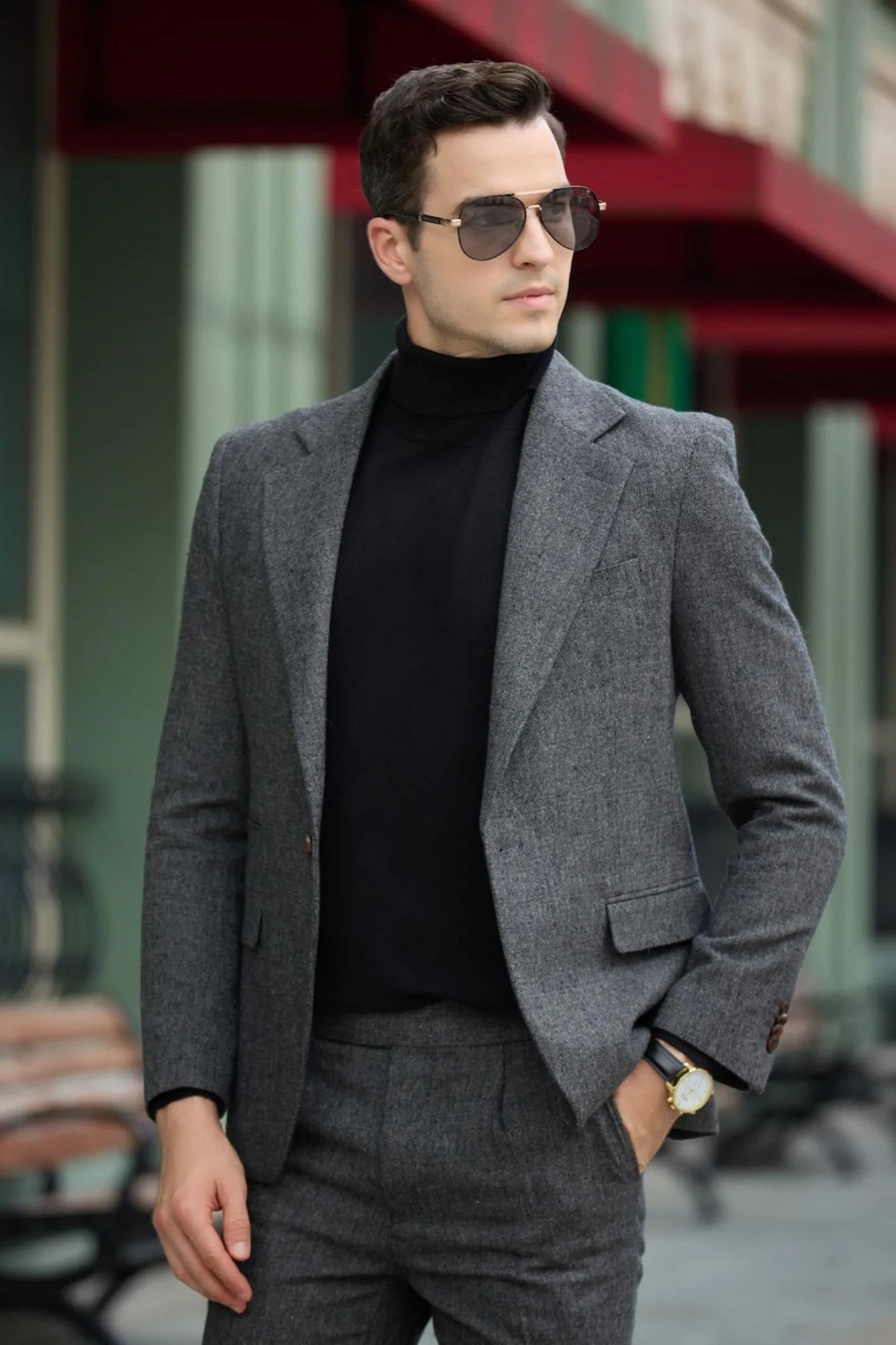close-up of men's dark grey tweed herringbone blazer, showing detailed stitching and lapel design.