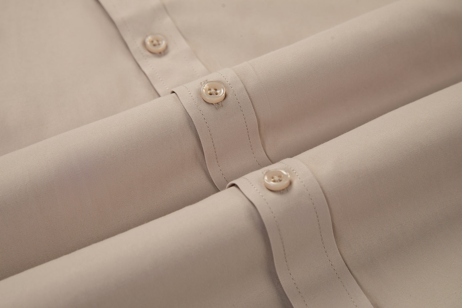 Cuff detail of champagne men’s shirt – buttoned barrel cuff with neat topstitching