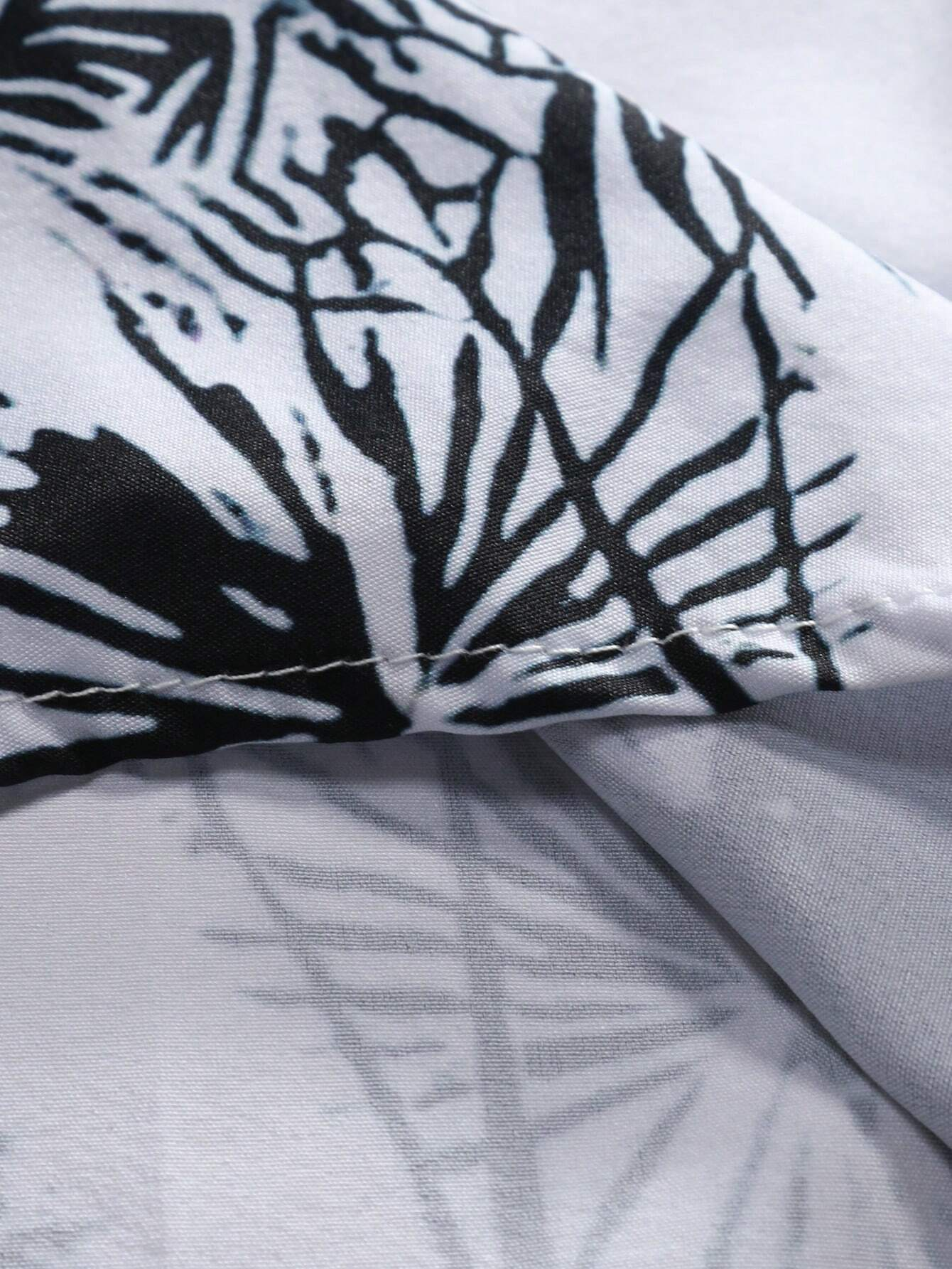 Inside hem stitching of black and white palm print shirt – men’s casual resort wear for vacation or beach