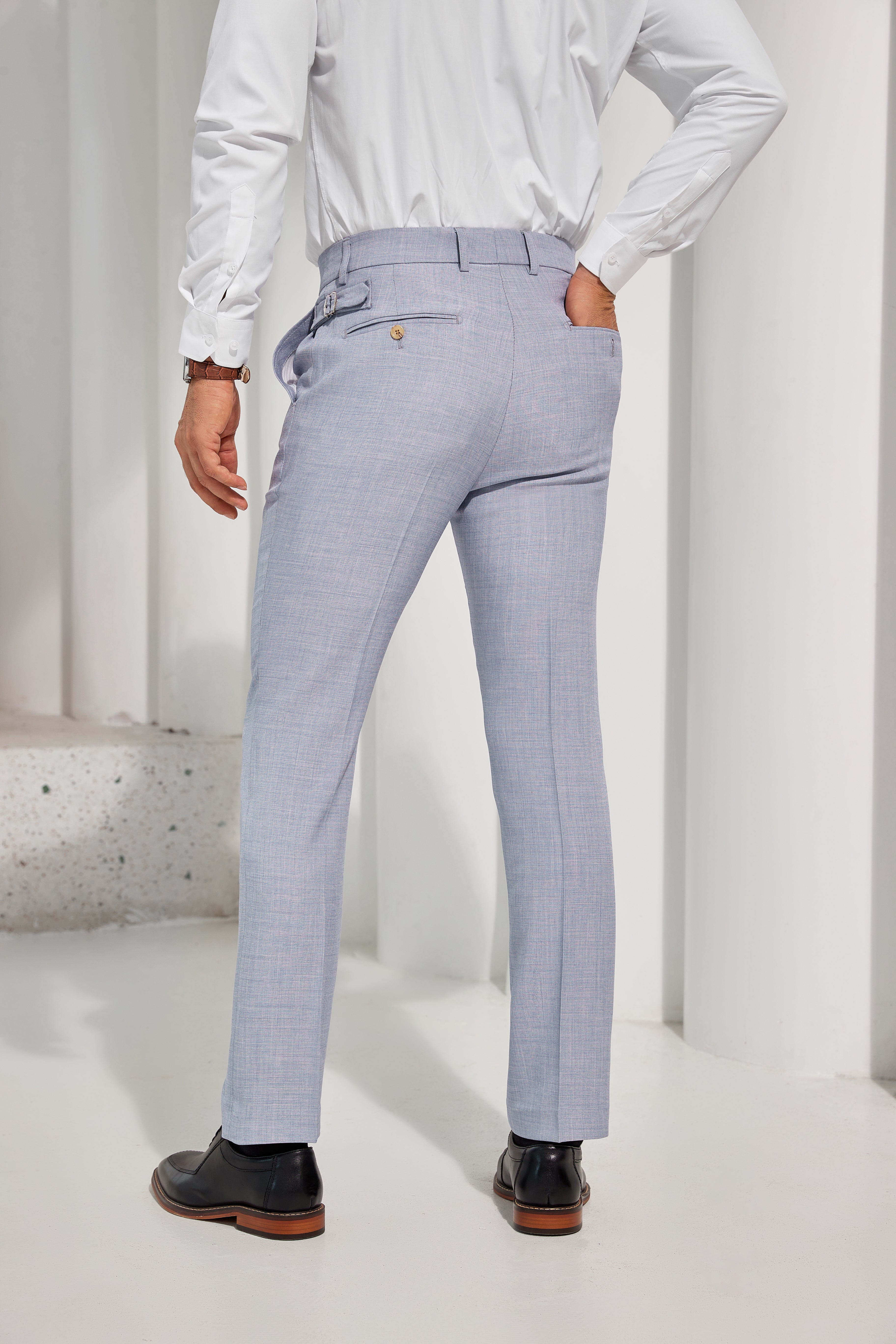 Back view of light blue tapered men’s trousers with buttoned pockets – party-ready formal style