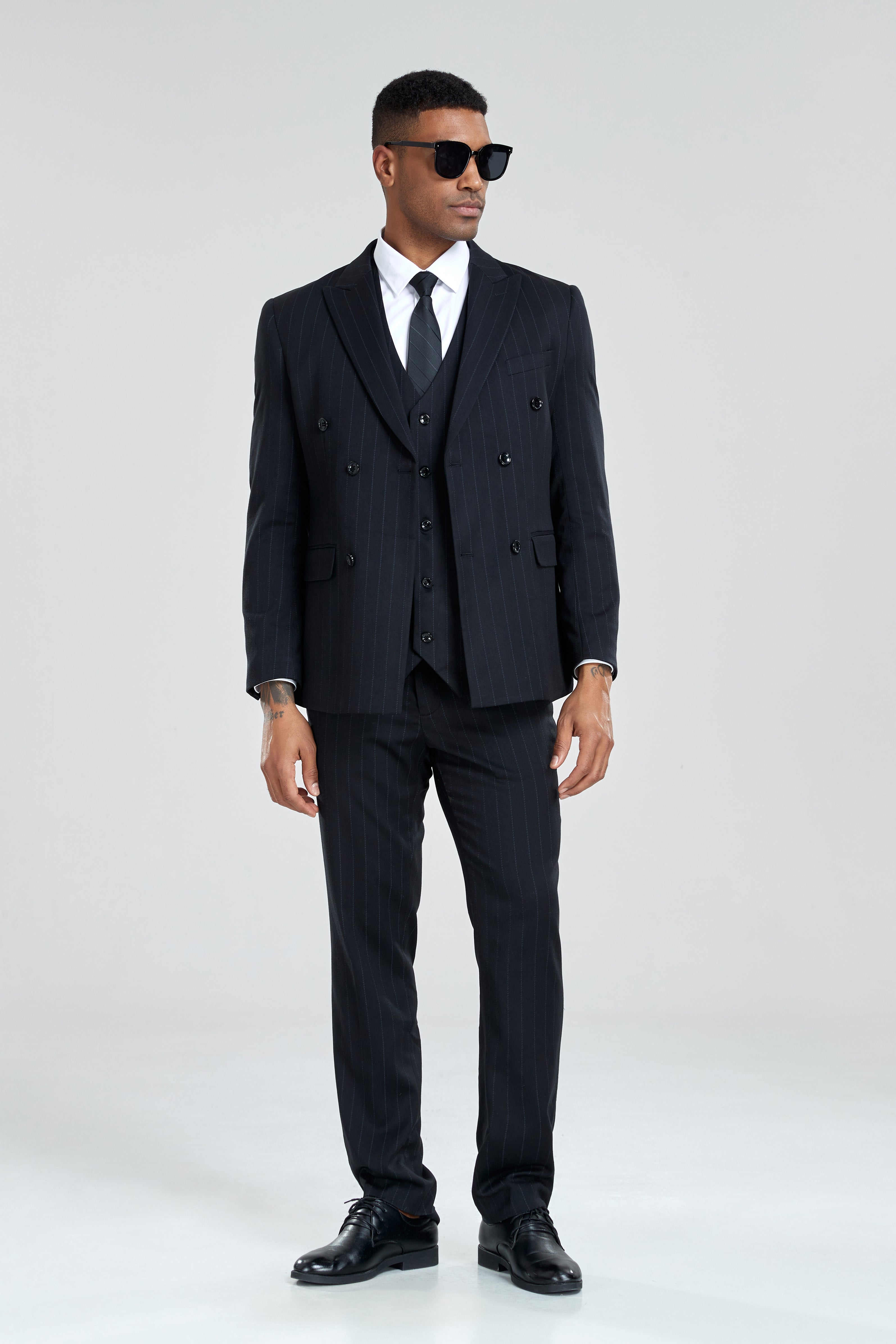 Model wearing fitted black pinstripe suit and formal shoes