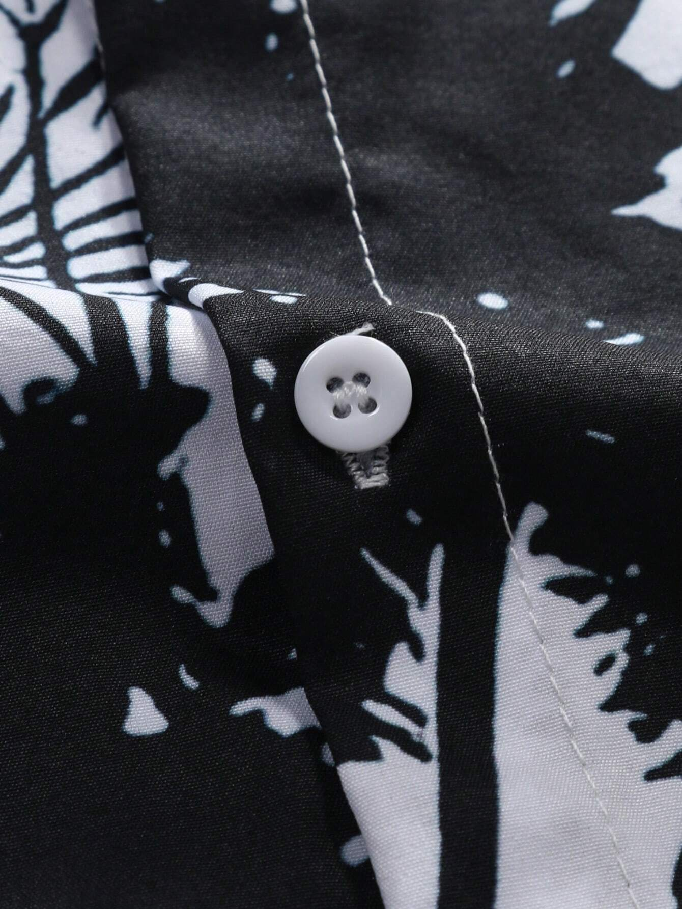 Close-up of button placket on white stand collar shirt – tropical black palm design for men's summer outfits
