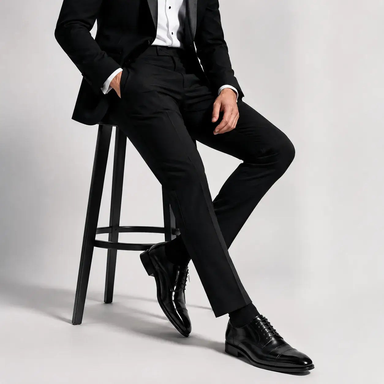 Polished black dress shoes with black prom suit trousers for men’s formal prom styling.