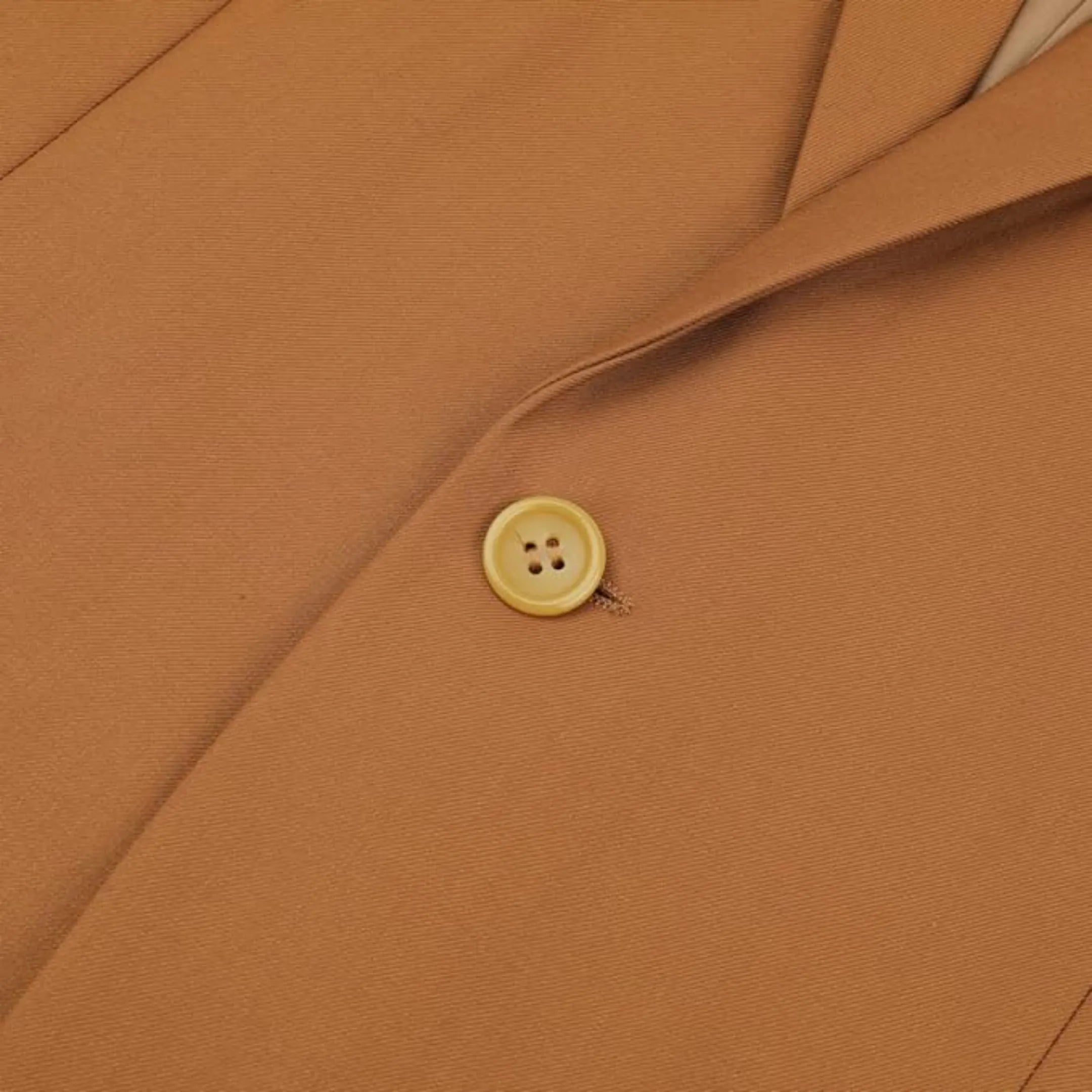 close-up of the button closure on men's caramel single-breasted blazer, with the golden button providing a contrasting finish to the stylish jacket.