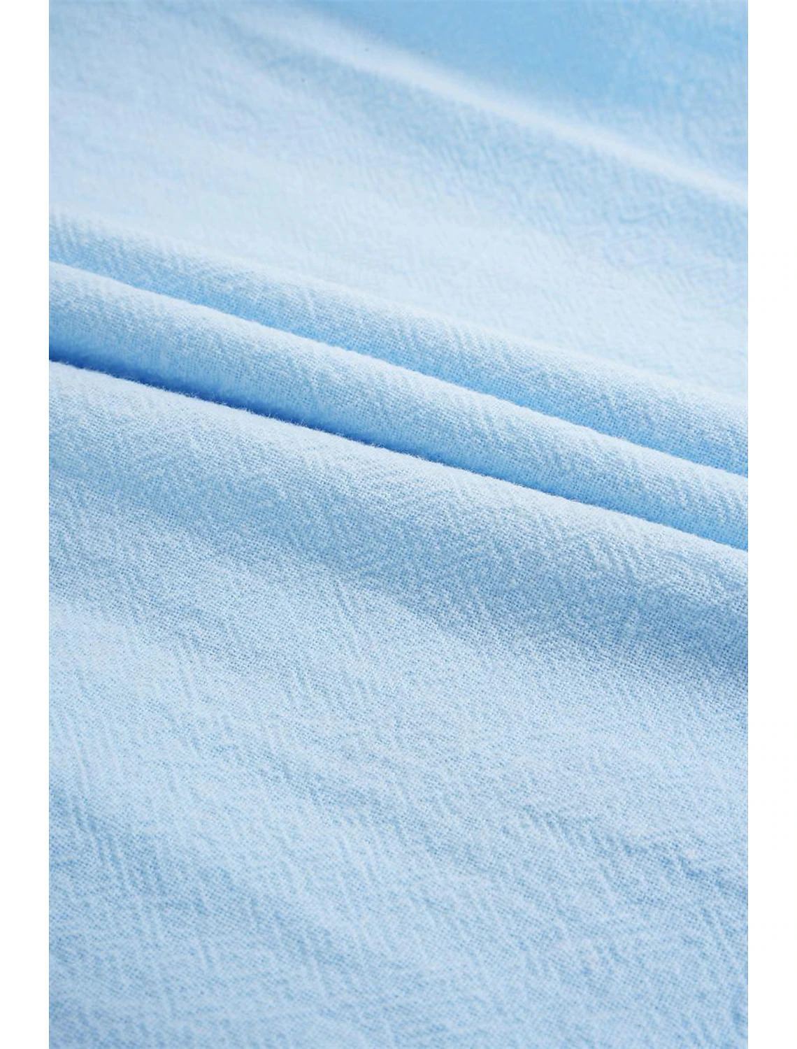 Close-up of textured light blue linen fabric – soft and lightweight material for casual shirts