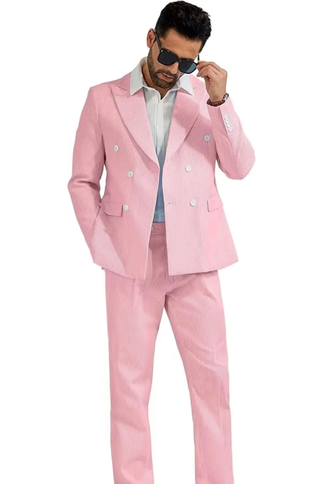 full body shot of a man wearing a men's pink seersucker double-breasted 2-piece suit, paired with a white shirt, creating a sharp summer look.