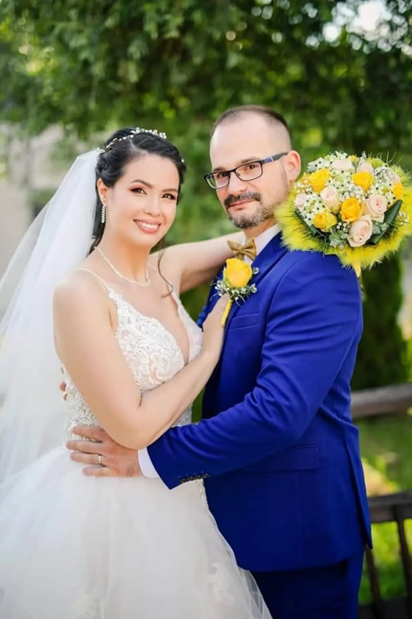 royal blue groom suit for outdoor wedding, styled with yellow boutonnière and bride in lace gown