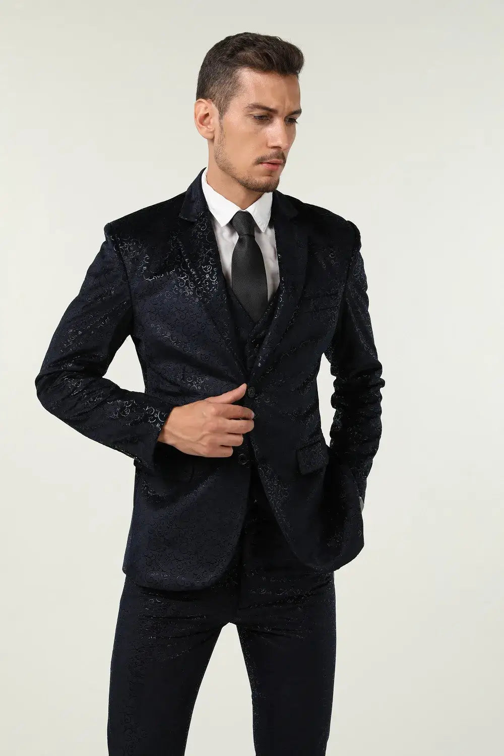 Side angle of men's navy patterned velvet 3 piece suit – adjusting jacket in slim fit prom tuxedo style