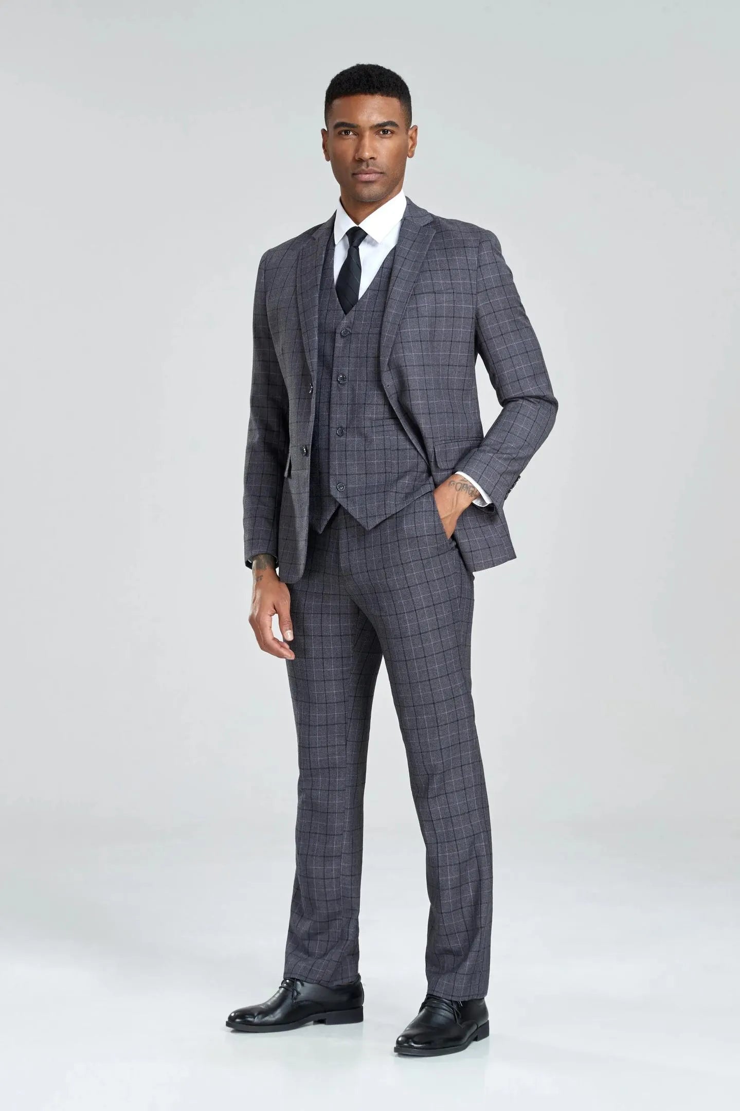 grey plaid 3-piece suit, front view, hands in pockets with jacket open, tailored slim silhouette.