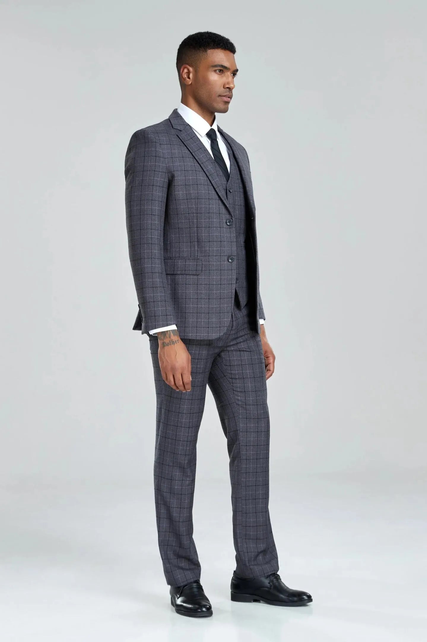 men’s grey plaid suit, three-quarter left angle, jacket open showing vest and check pattern.