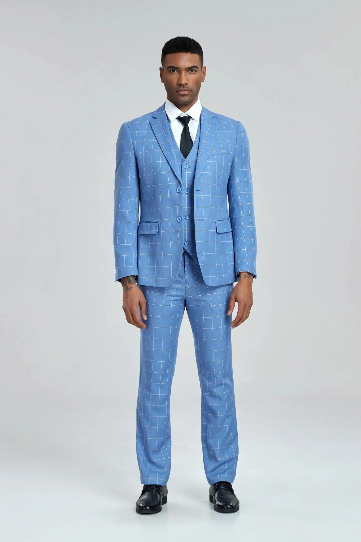 front view of the model in light blue plaid 3-piece suit, posing with a formal business look.