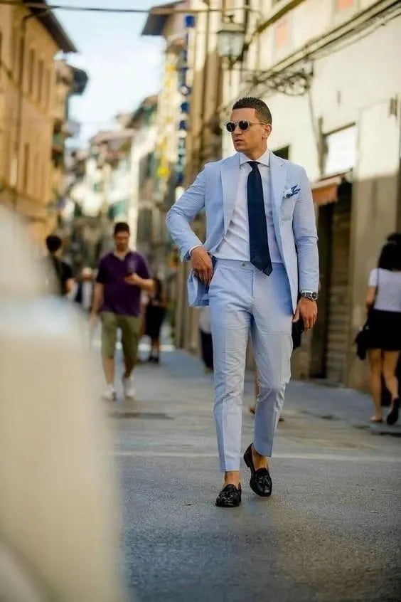 Stylish man in light blue blazer walking through the city, showcasing regular fit men’s seersucker design.