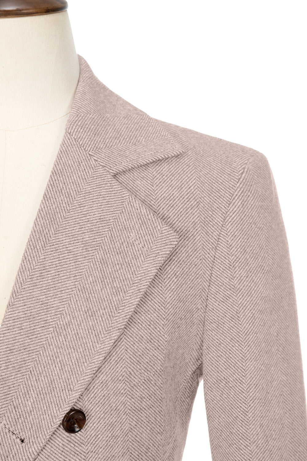 Close-up of lapel detail on apricot double-breasted wool coat
