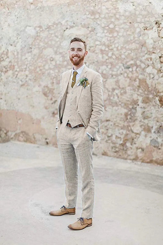 Beige 3 piece linen suit for men with blazer, vest, and pants – summer wedding outfit styled with tie and boutonniere for retro beach groom look.