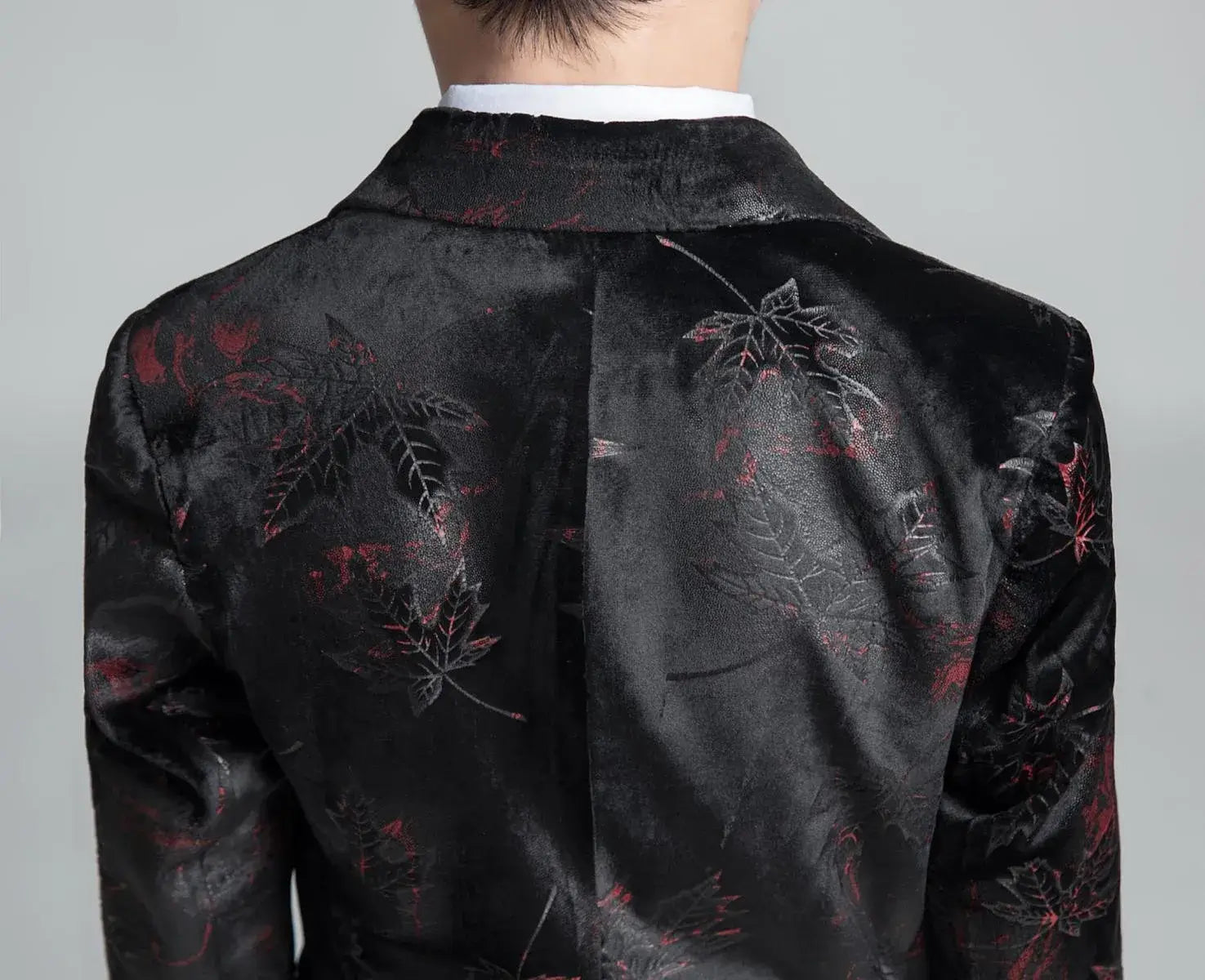 Close-up of boys' black jacquard suit back with red leaf embroidery and velvet texture, formal event wear