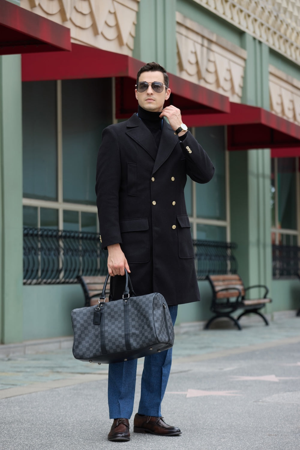 Men’s black overcoat styled with blue pants and sunglasses – elegant winter outerwear