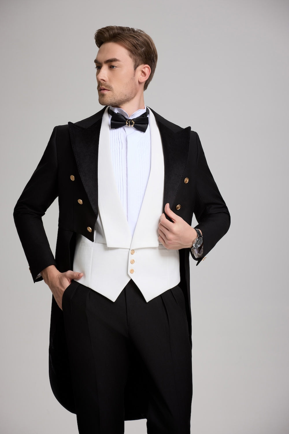 Close-up of black tuxedo tailcoat with gold buttons and white shawl vest – elegant men’s formalwear