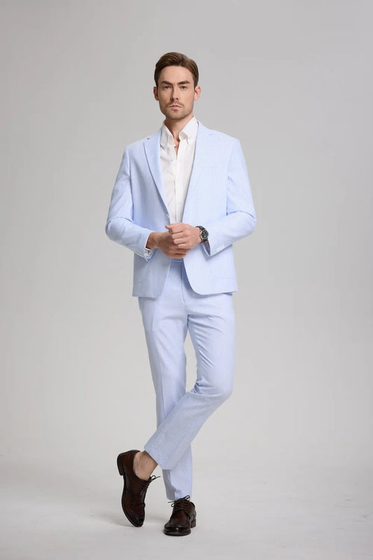 Full-body view of man in blue striped seersucker suit with white shirt and brown shoes