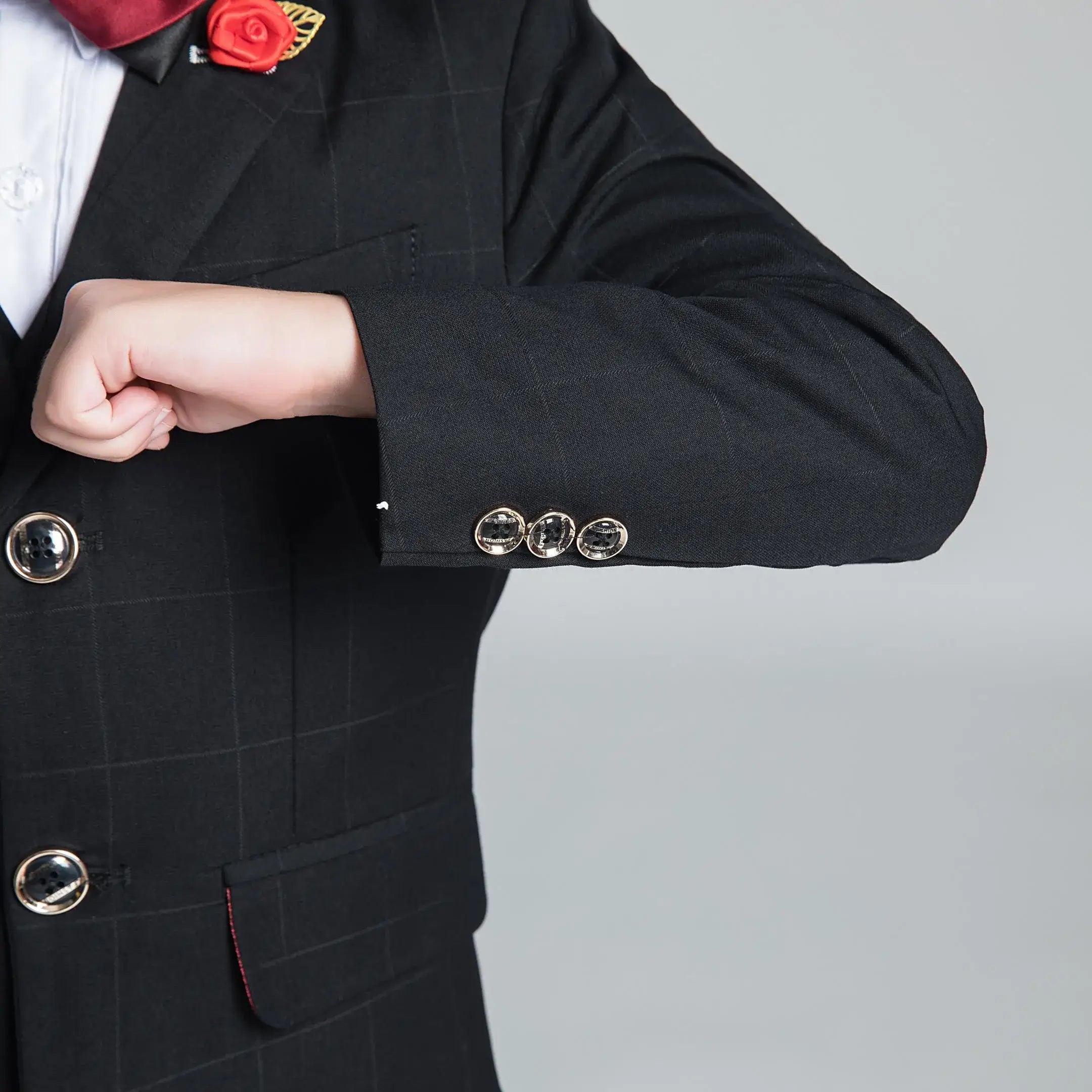 Black plaid boys' suit cuff with gold-trimmed buttons and sharp slim-fit finish