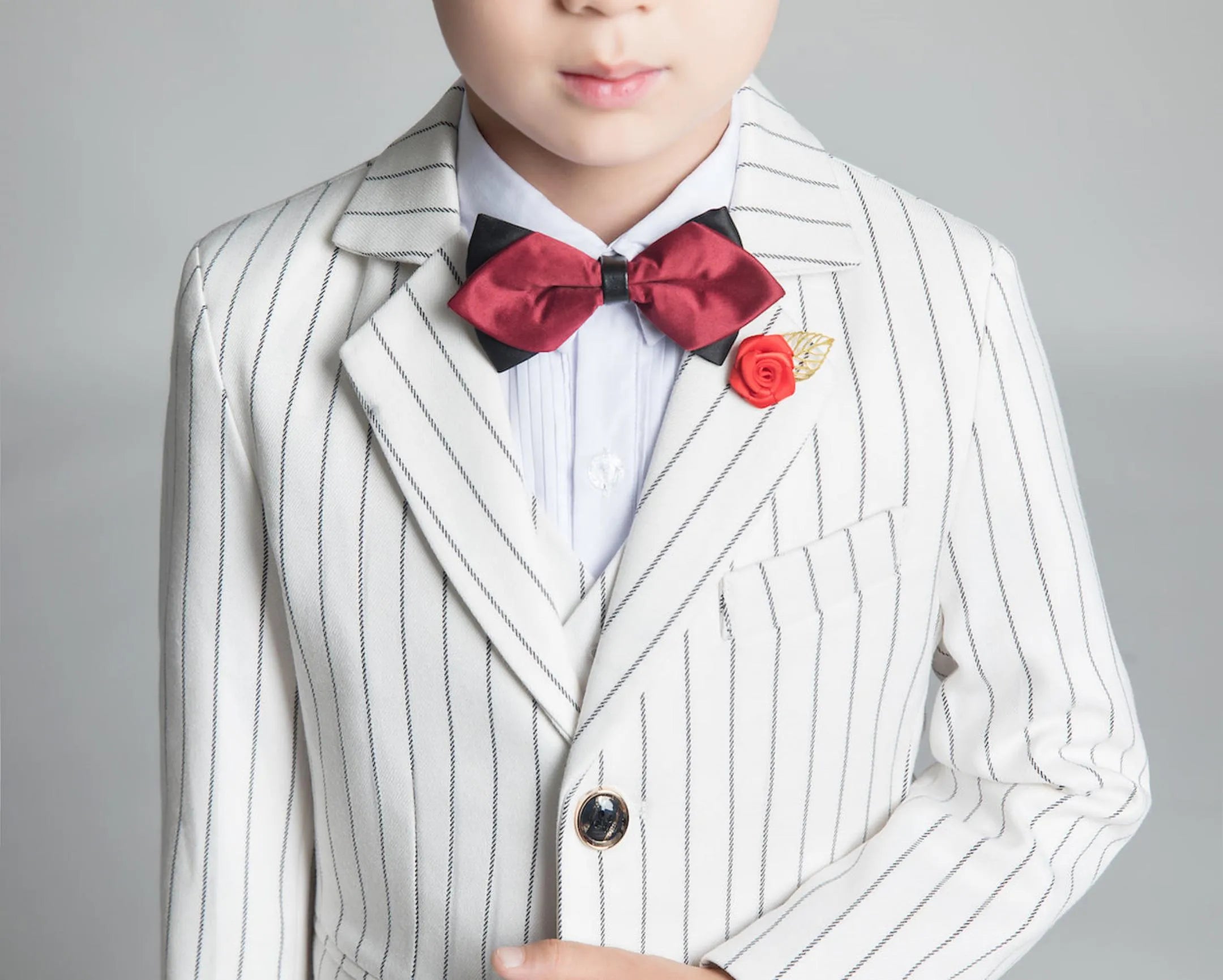 Front close-up of white striped suit with red bow tie and gold pin – stylish 5-piece boy's suit set
