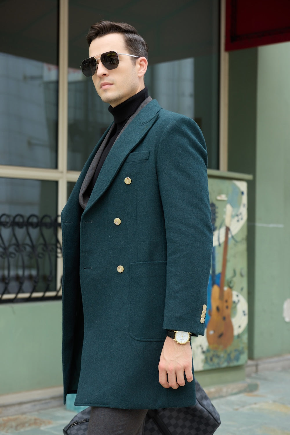 Men's green wool overcoat - side view of double breasted long winter coat with gold buttons and cuff details, walking in urban street scene