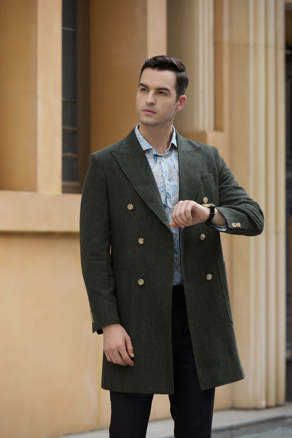 Man wearing green wool double breasted overcoat checking watch in winter street setting
