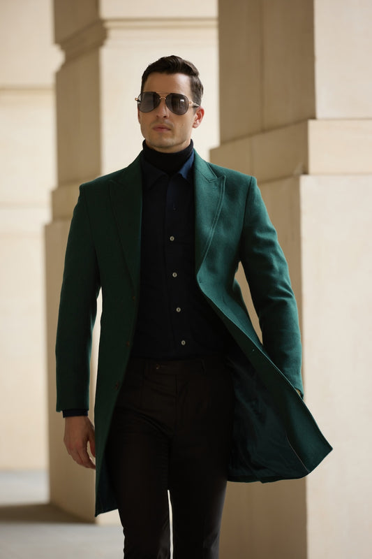 Man wearing green wool trench coat with pockets, styled for winter street fashion