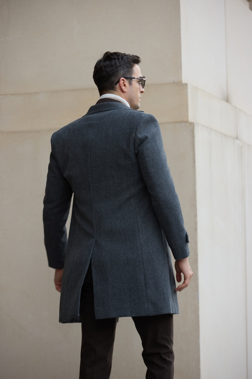 Back view of grey double breasted men’s overcoat – center vent and clean tailoring