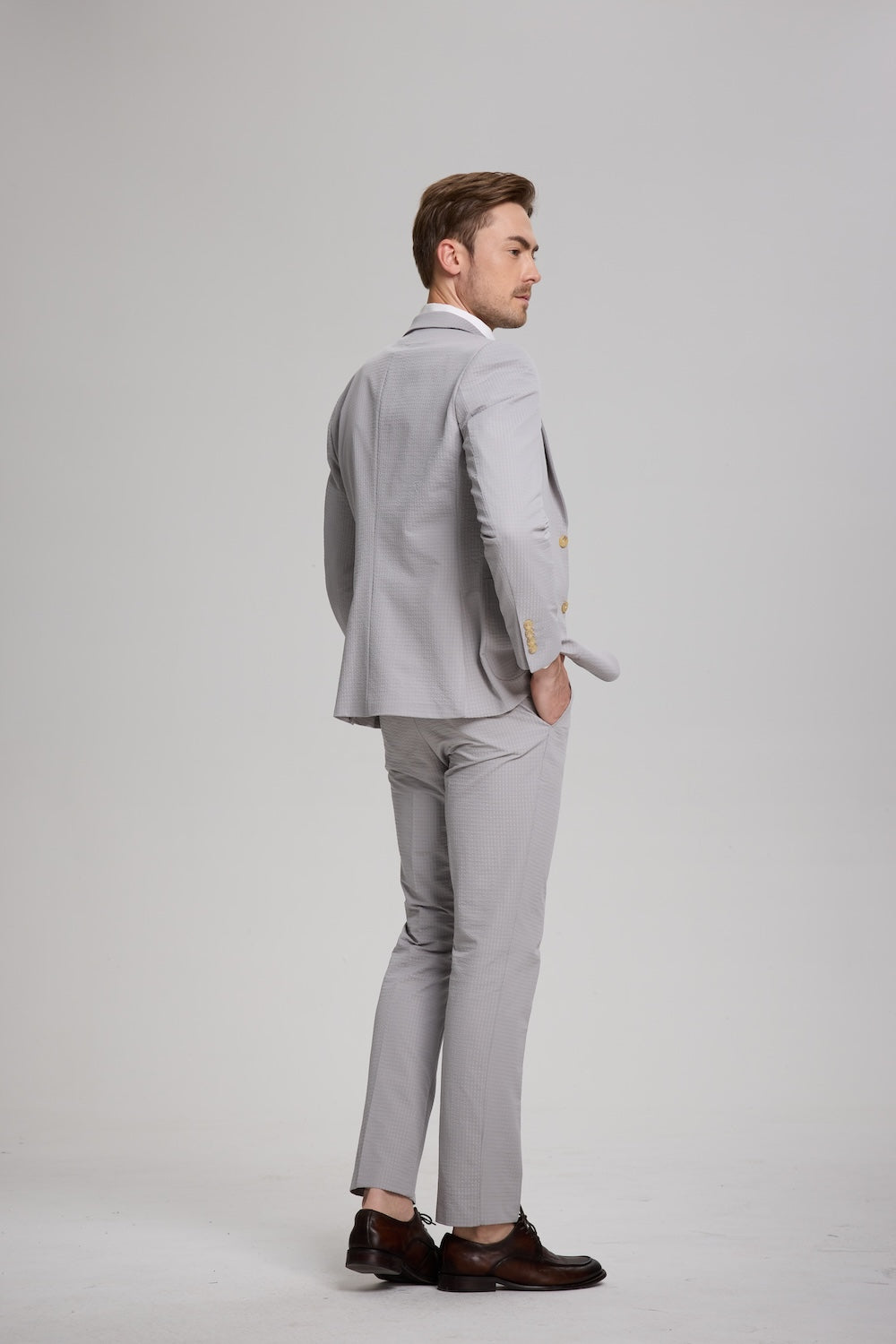 Back angle of light grey striped seersucker suit with hands in pockets