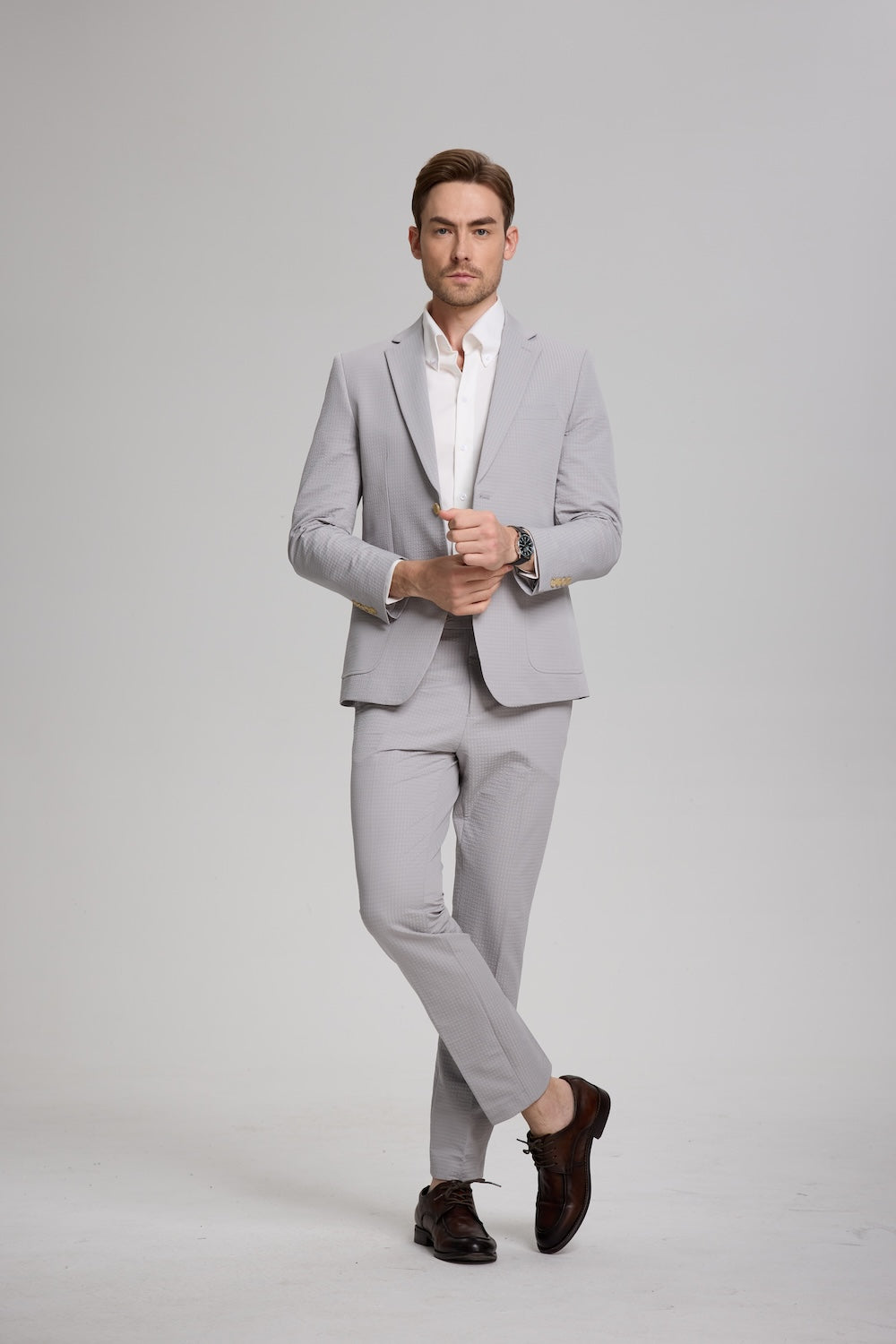 Front-facing grey blazer look with white shirt and subtle summer texture