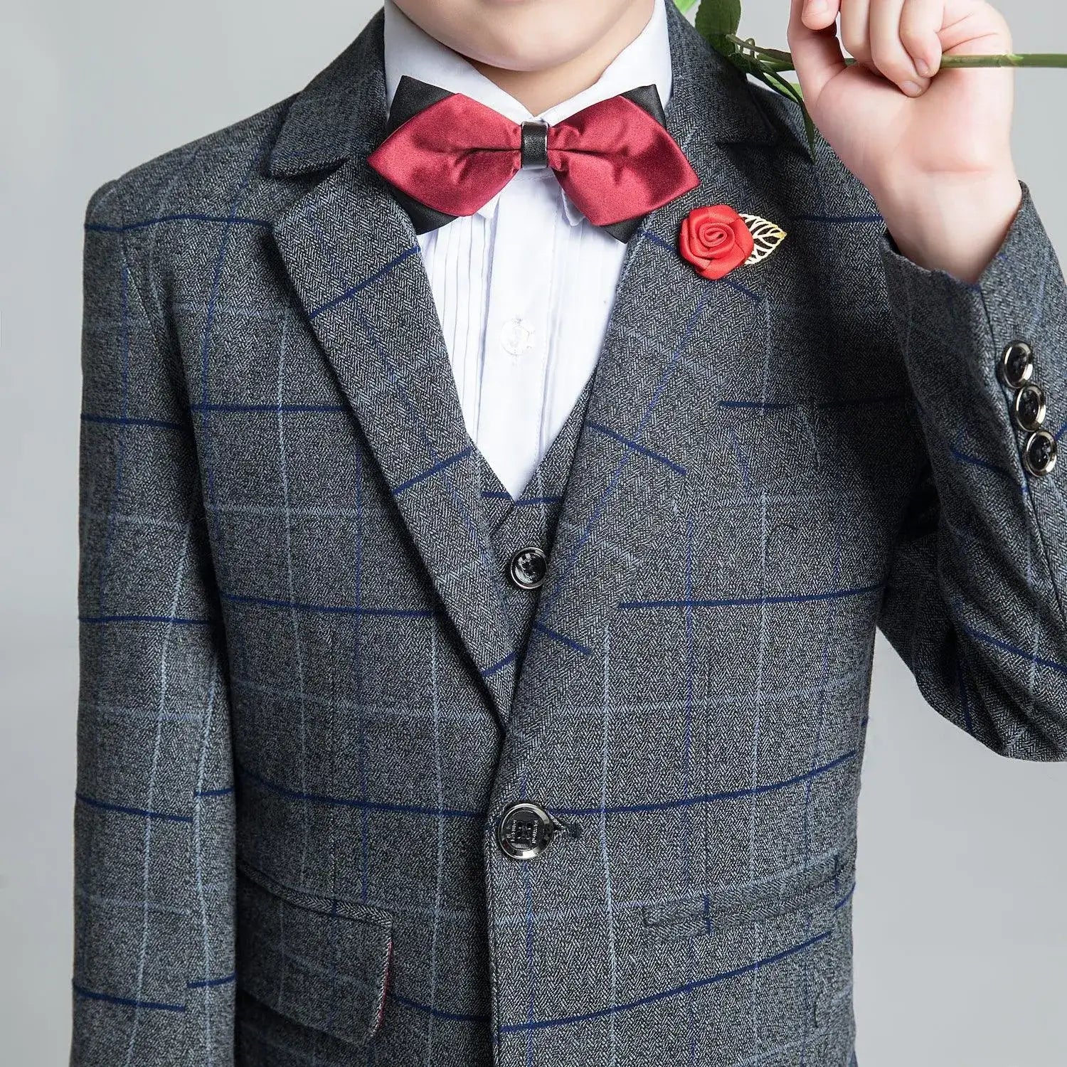 Boys' dark gray plaid suit: Close-up of red bow tie & rose lapel pin