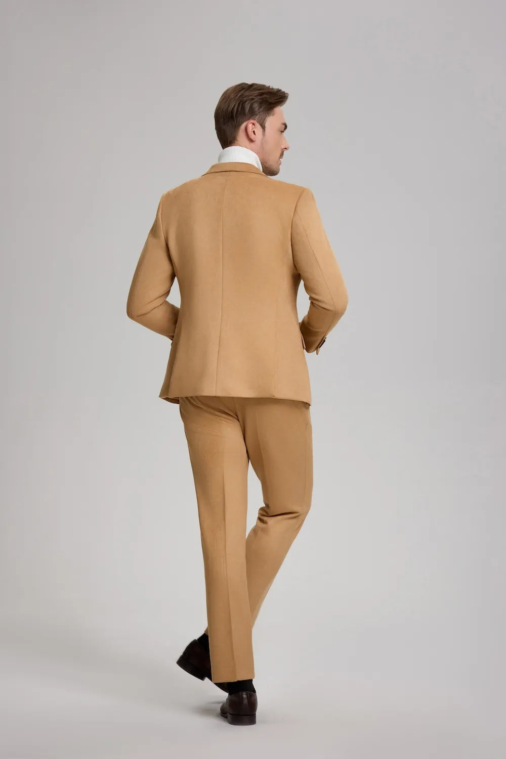 Back view of a man in a light brown suede 2-piece suit with peak lapel, showcasing the suit's structured fit.
