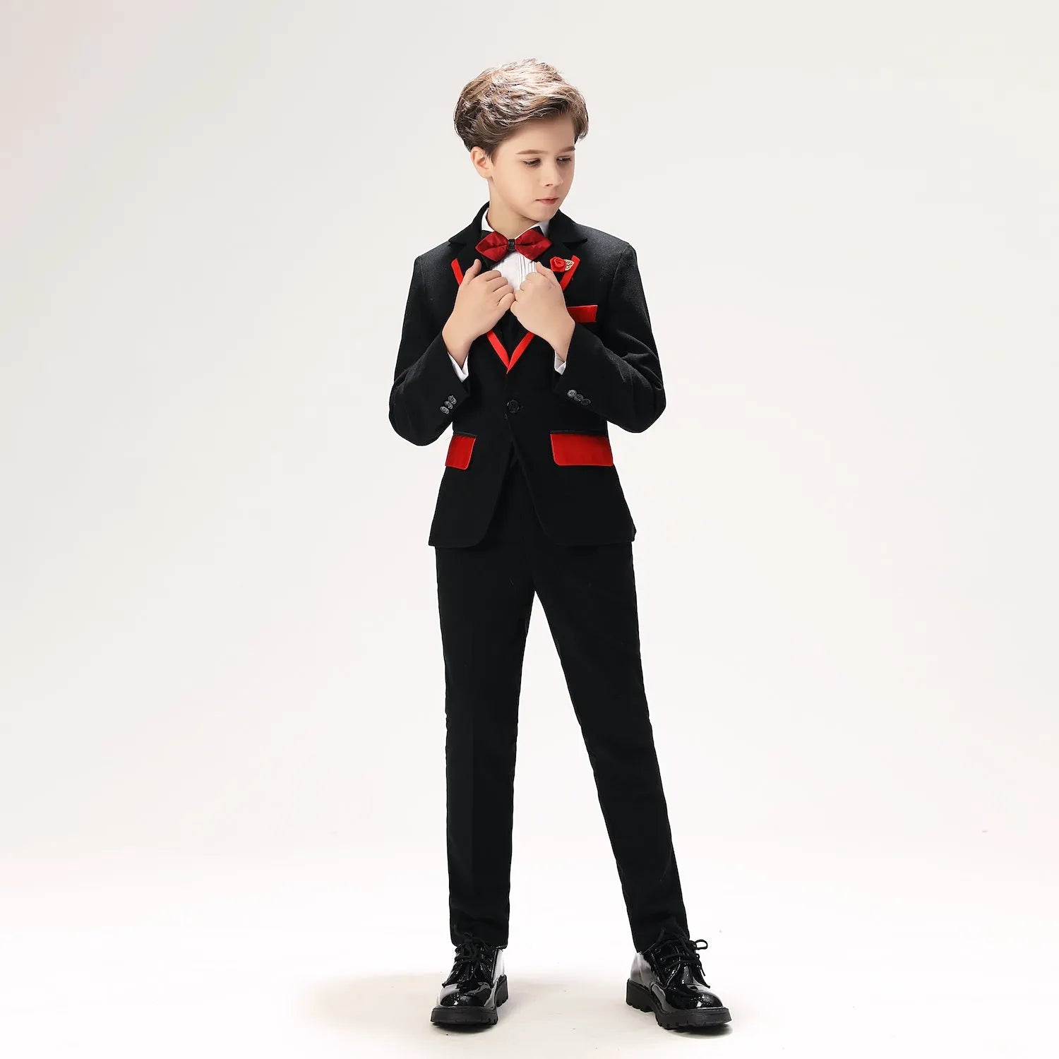 Stylish black 5-piece boys' formal outfit with red accents, bow tie, and flower lapel, prom-ready full body look