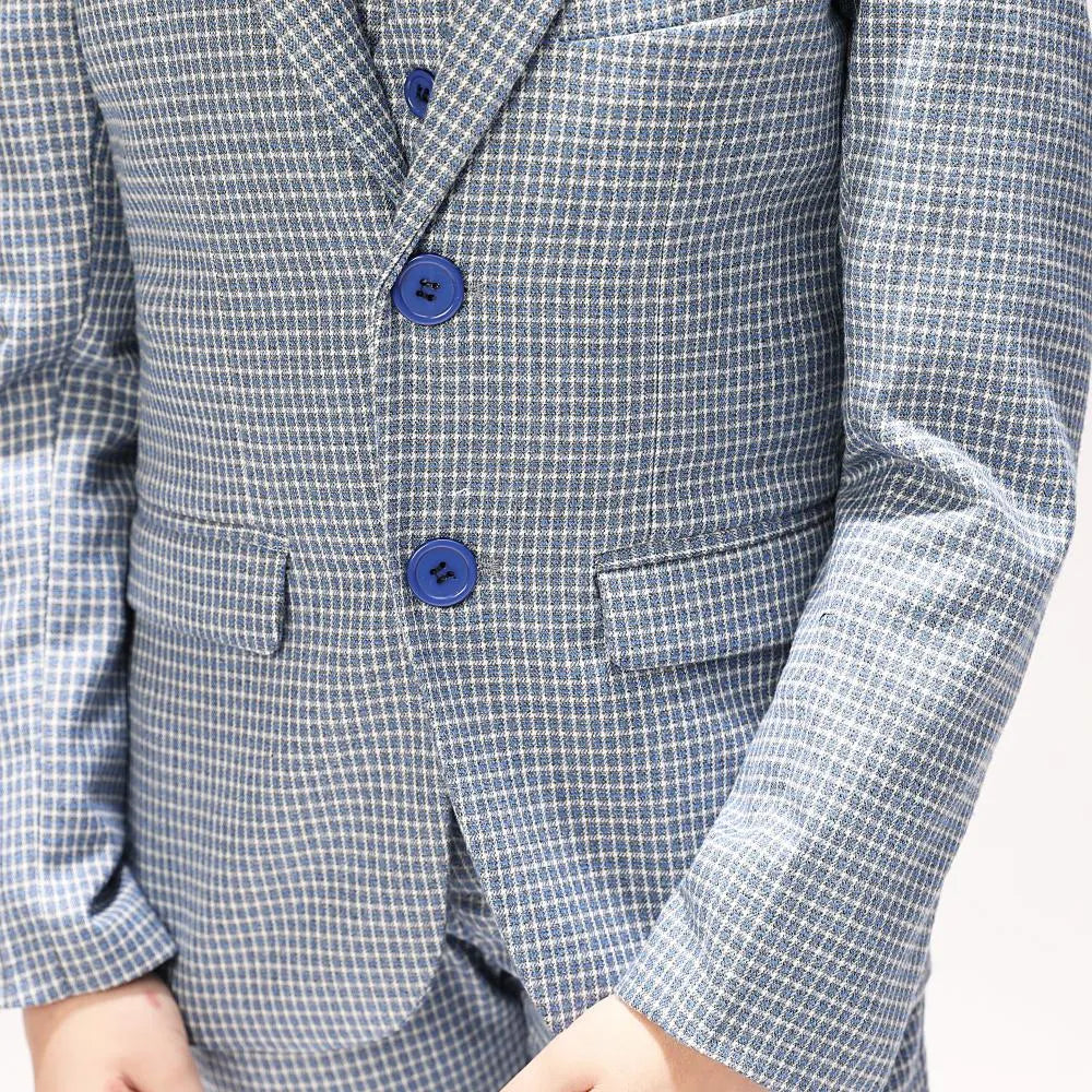 Close-up of blazer pockets and buttons on black and white boys' plaid formal suit