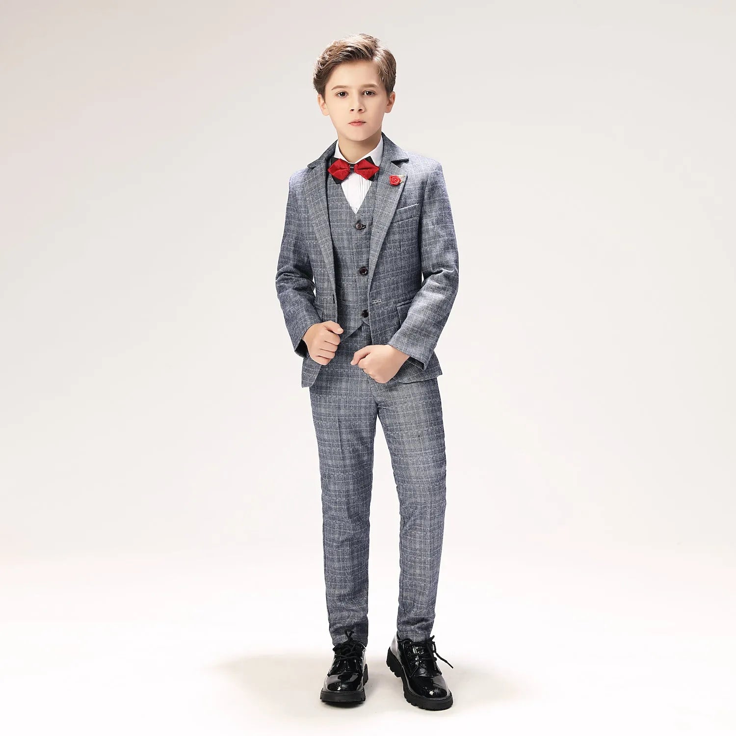 Full-length view of elegant boys suit set in grey plaid with fitted blazer, vest, and trousers