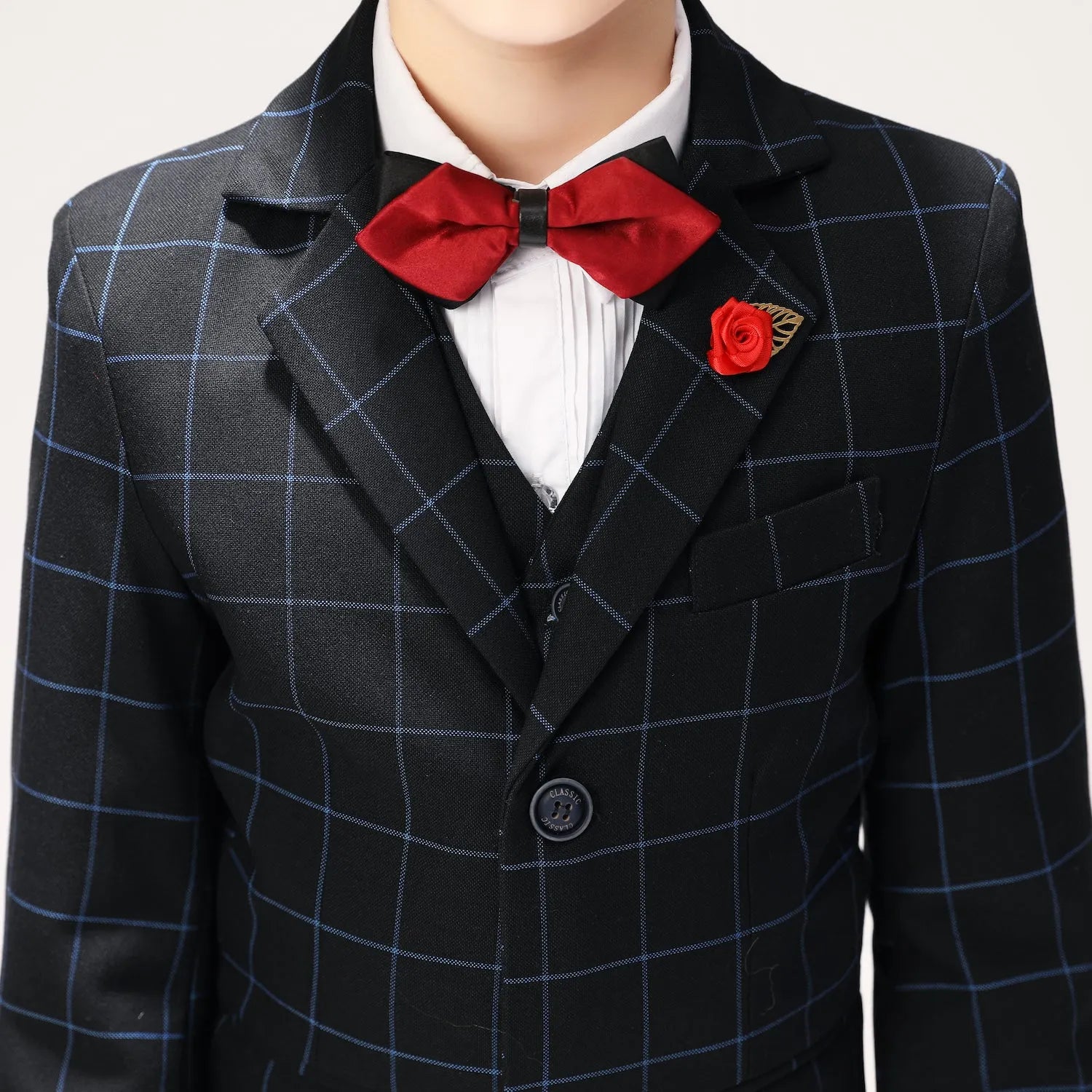 Close-up of red bow tie and boutonnière on navy checkered boys suit for wedding events
