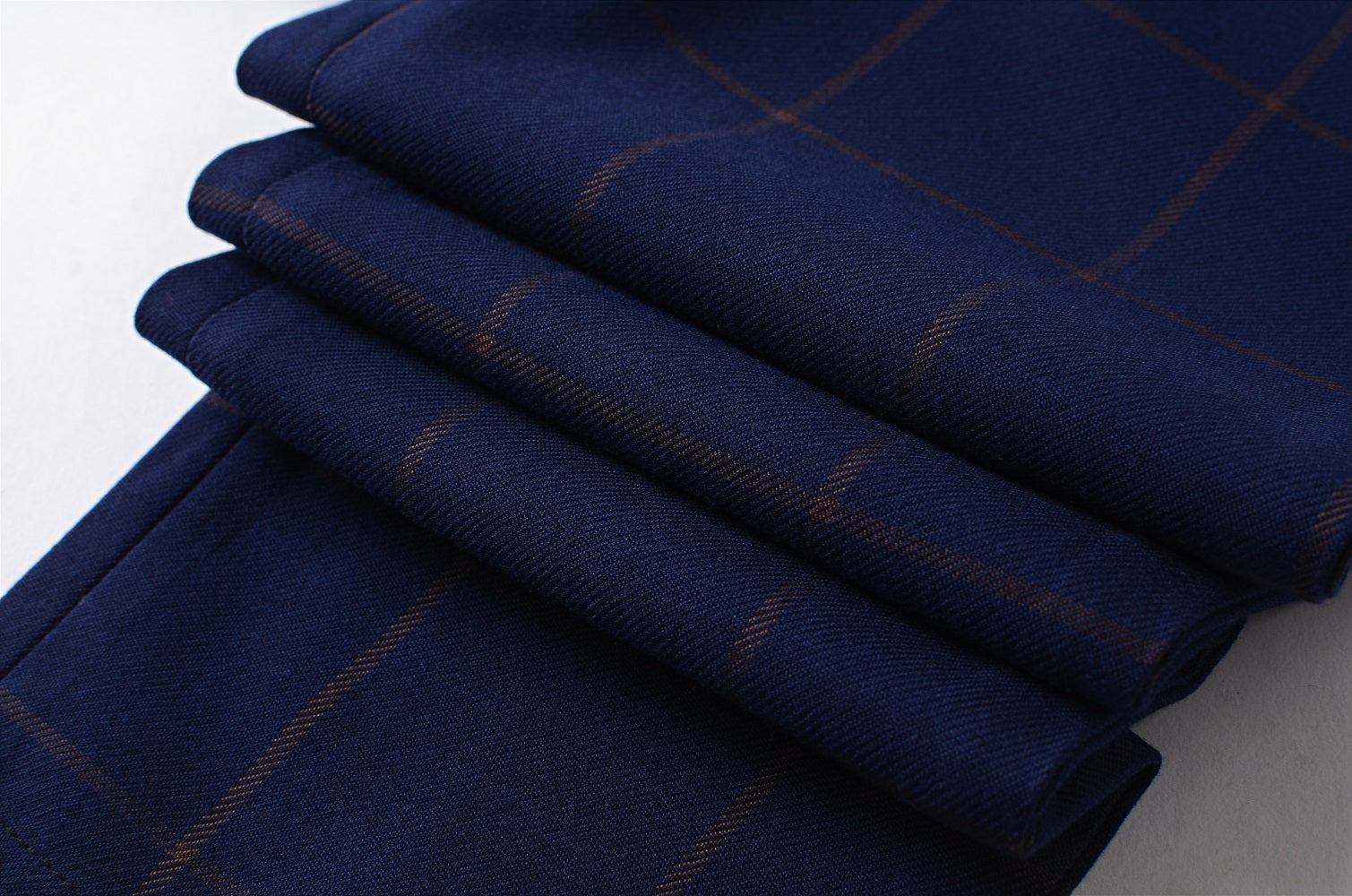 Close-up texture of navy plaid fabric, highlighting quality weave and checked pattern